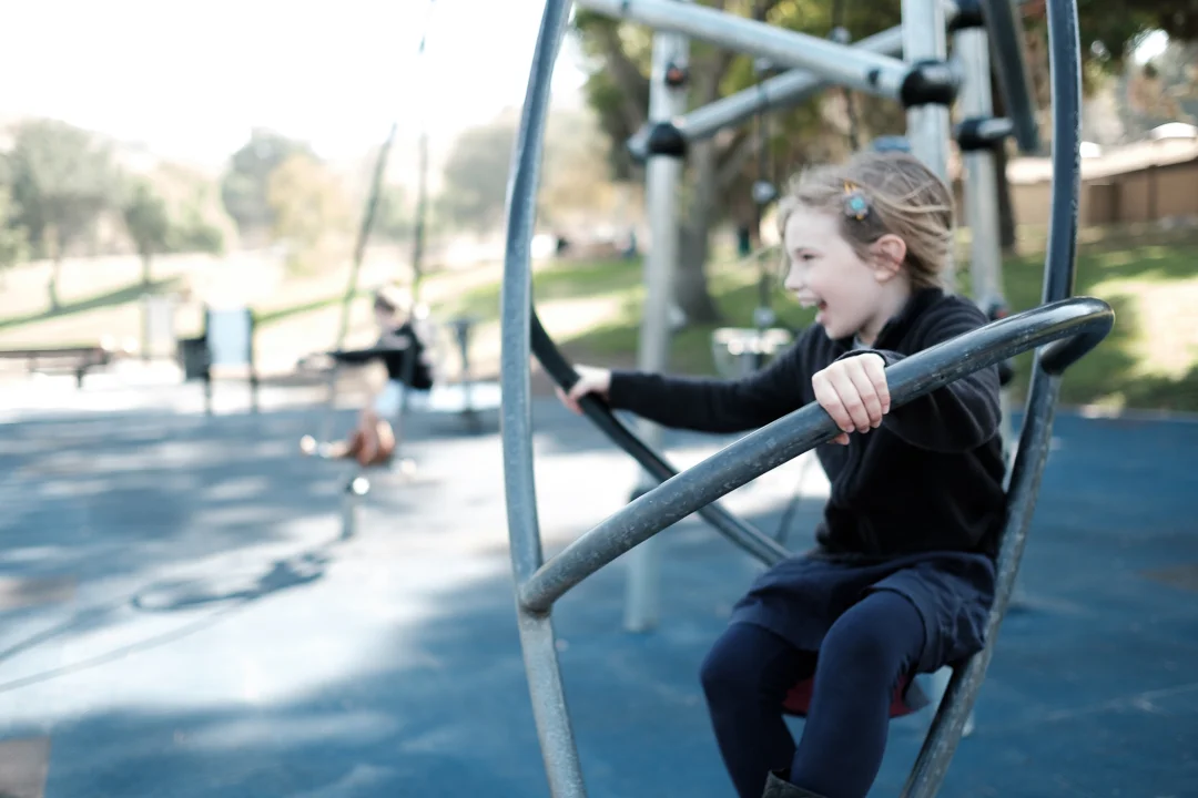 A sweet photo of a girl on playground equipment in San Dimas, CA by documentary photographer Erica Faith Walker.