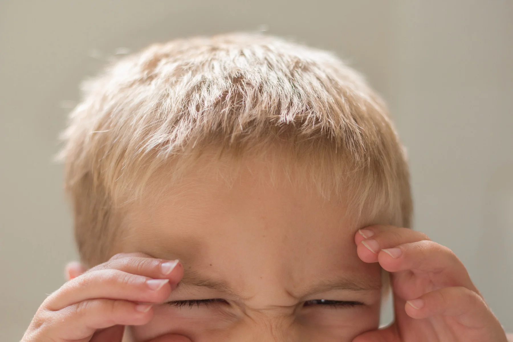 A close up photo of just the eyes of a preschool boy.