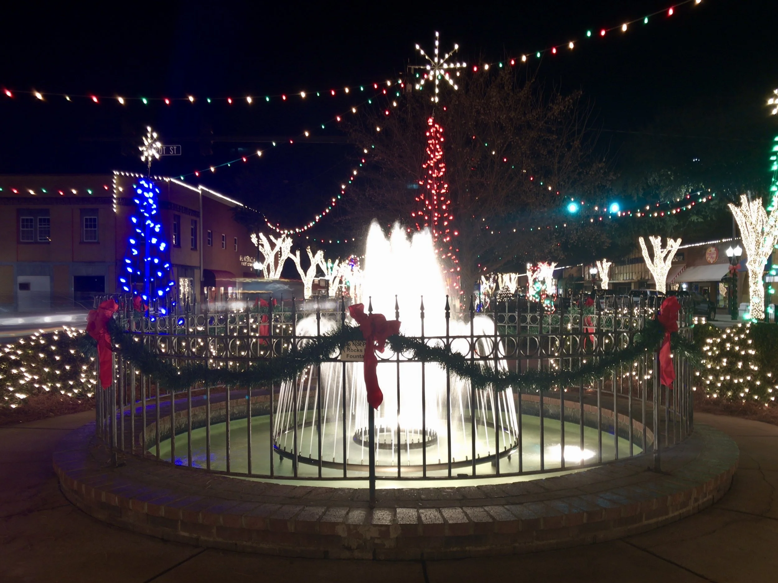 Downtown fountain and trees lit up for the holidays at night