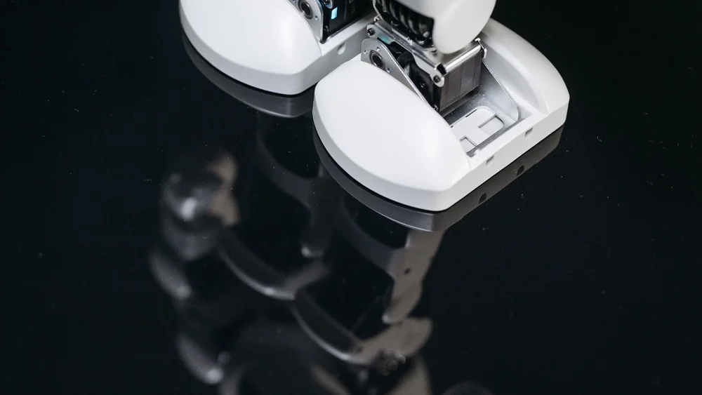 Robot legs and joints reflected on a dark surface