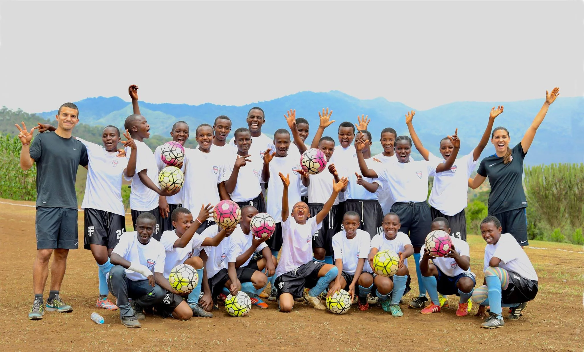 Sports Envoys and U.S. Women’s National Team member, Alex Morgan, and Orlando City player Servando Carrasco celebrate with youth after a clinic in Tanzania. 2017. 