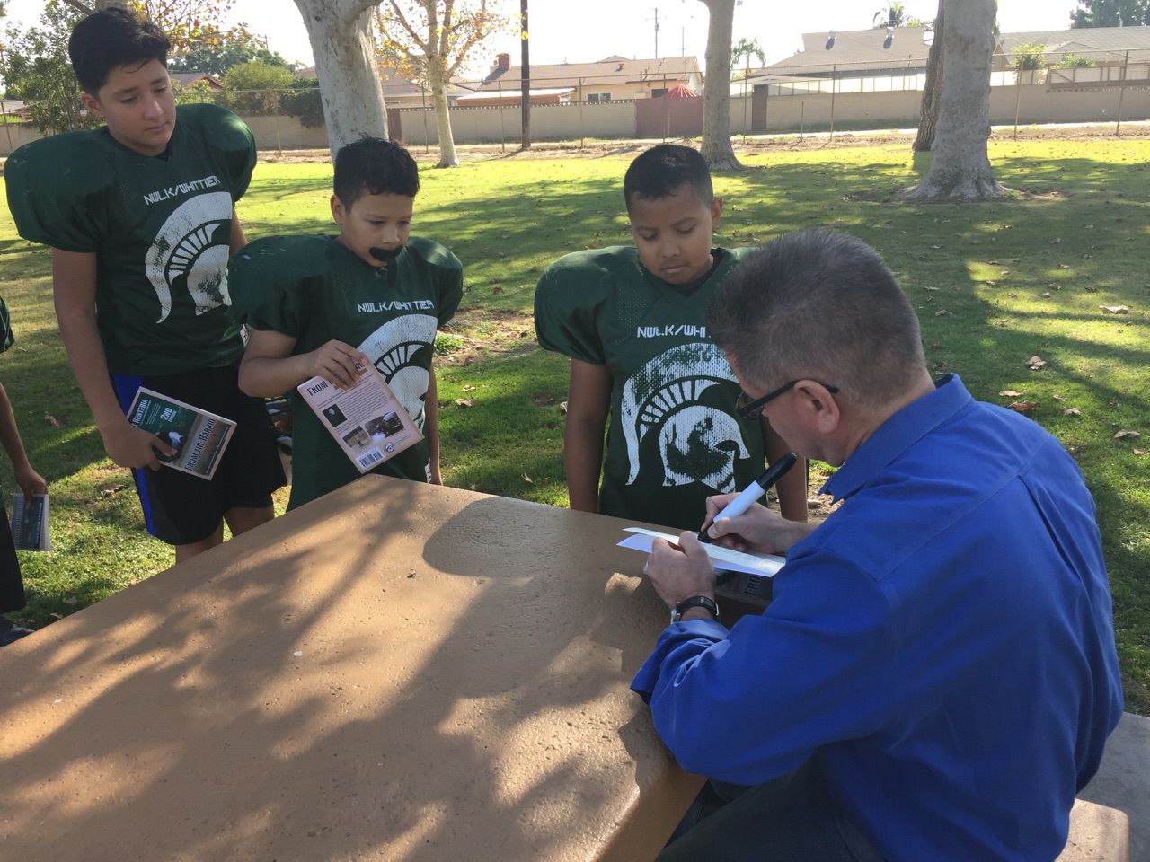 Barrio autographing books for kids in California Coach-Victor H Valdez Sr.jpg