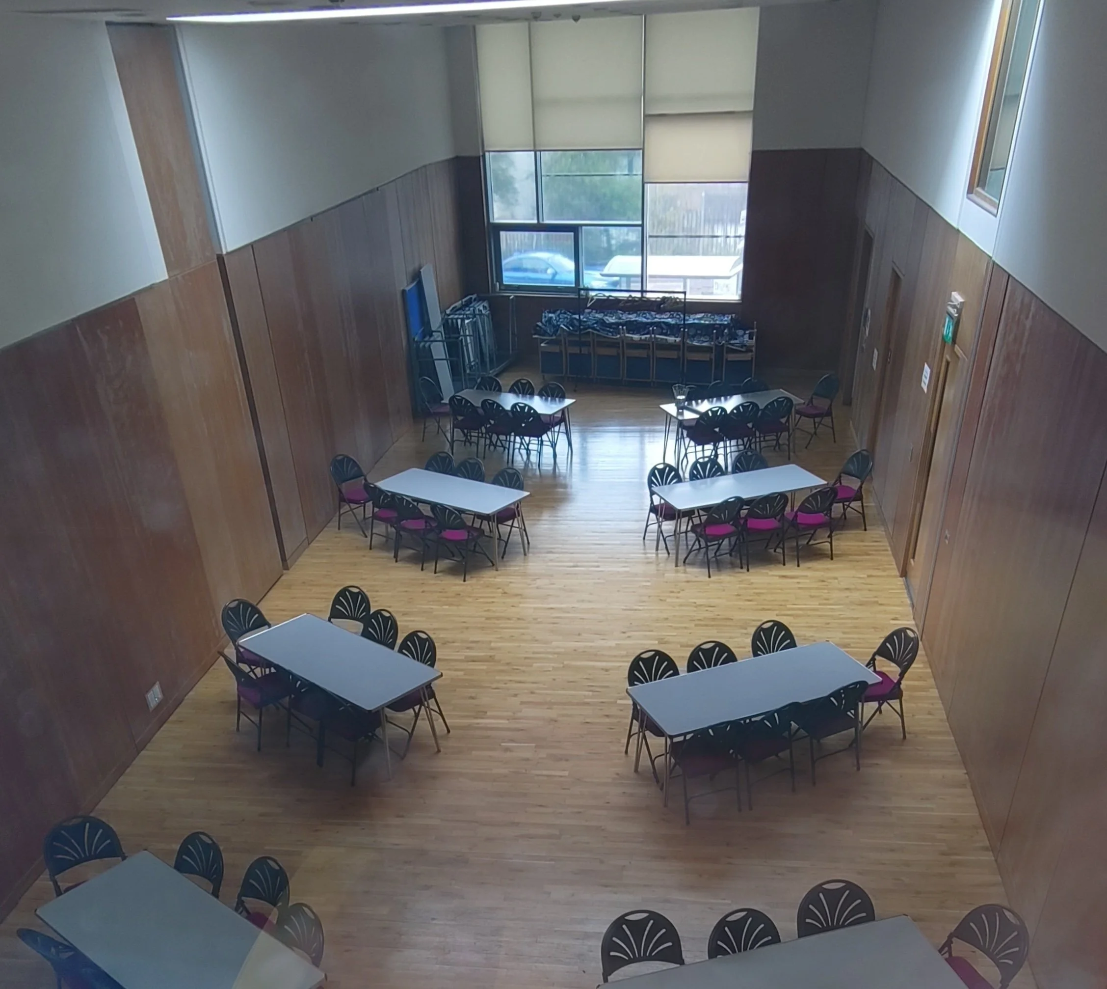 Tables and chairs in a church hall, seen from above.