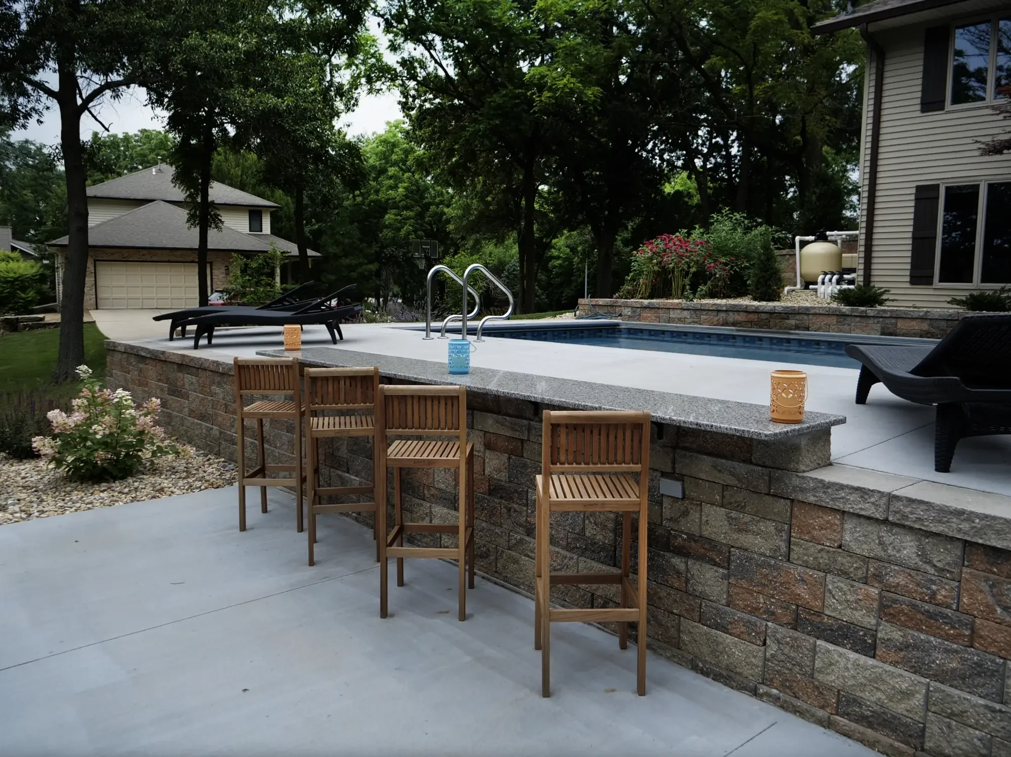 tone retaining wall with granite bar top overlooking pool surround at The Amphitheater by Green View in Illinois