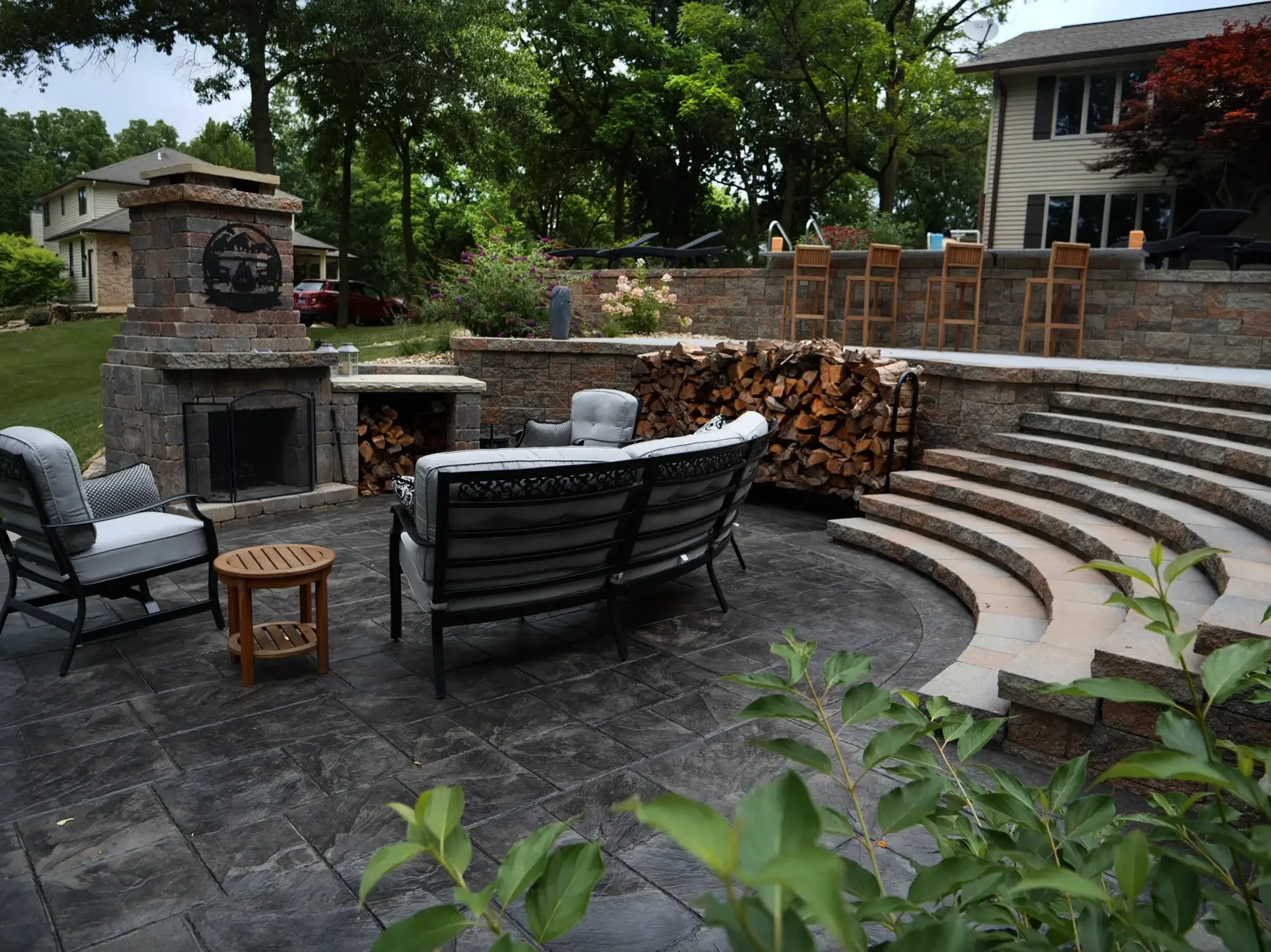 tone outdoor fireplace and curved amphitheater steps with stamped patio at The Amphitheater by Green View in Illinois