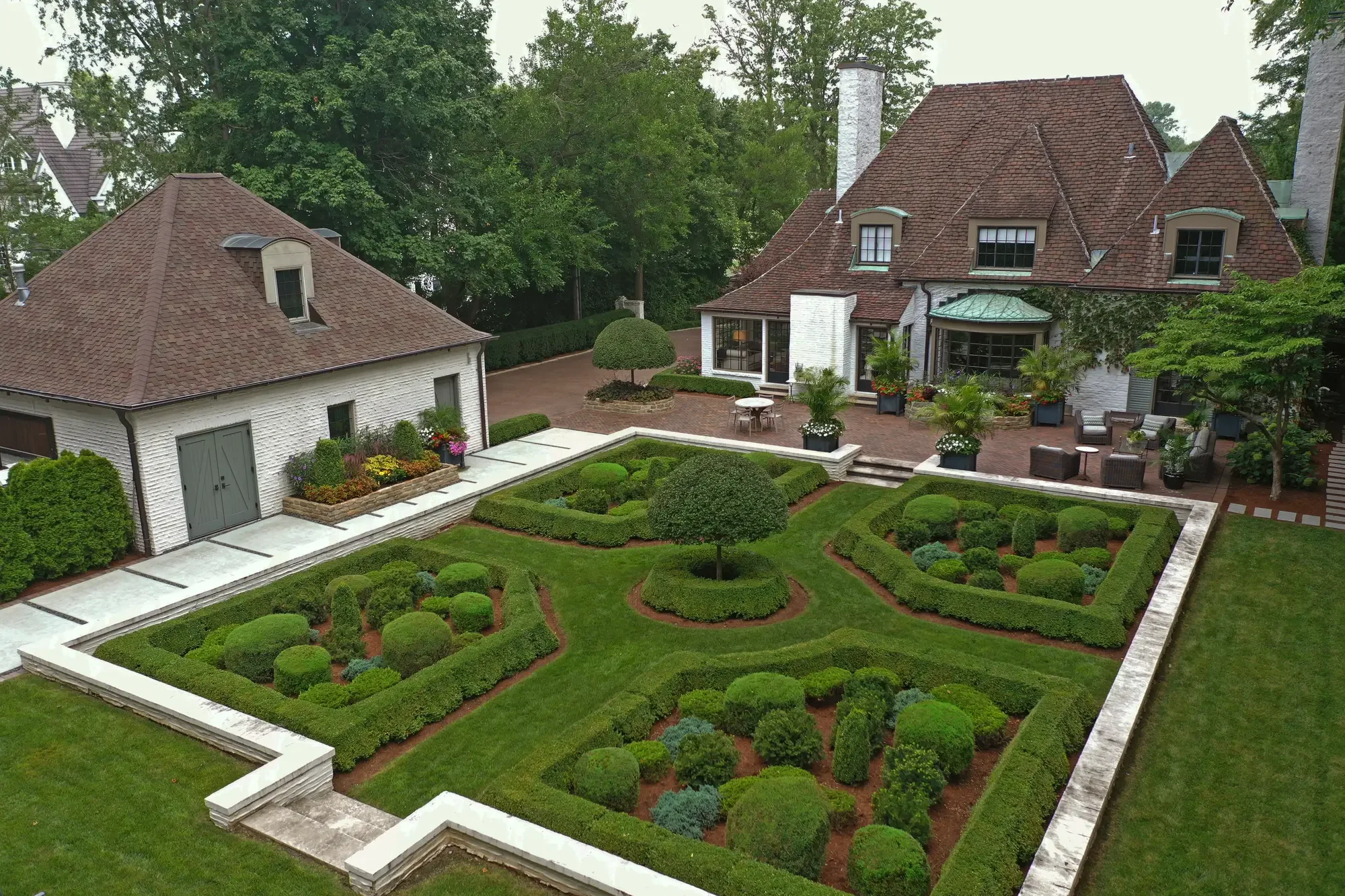 Wide aerial view of formal knot garden, carriage house, and full estate grounds at The Tudor Knot Garden by Green View in Illinois