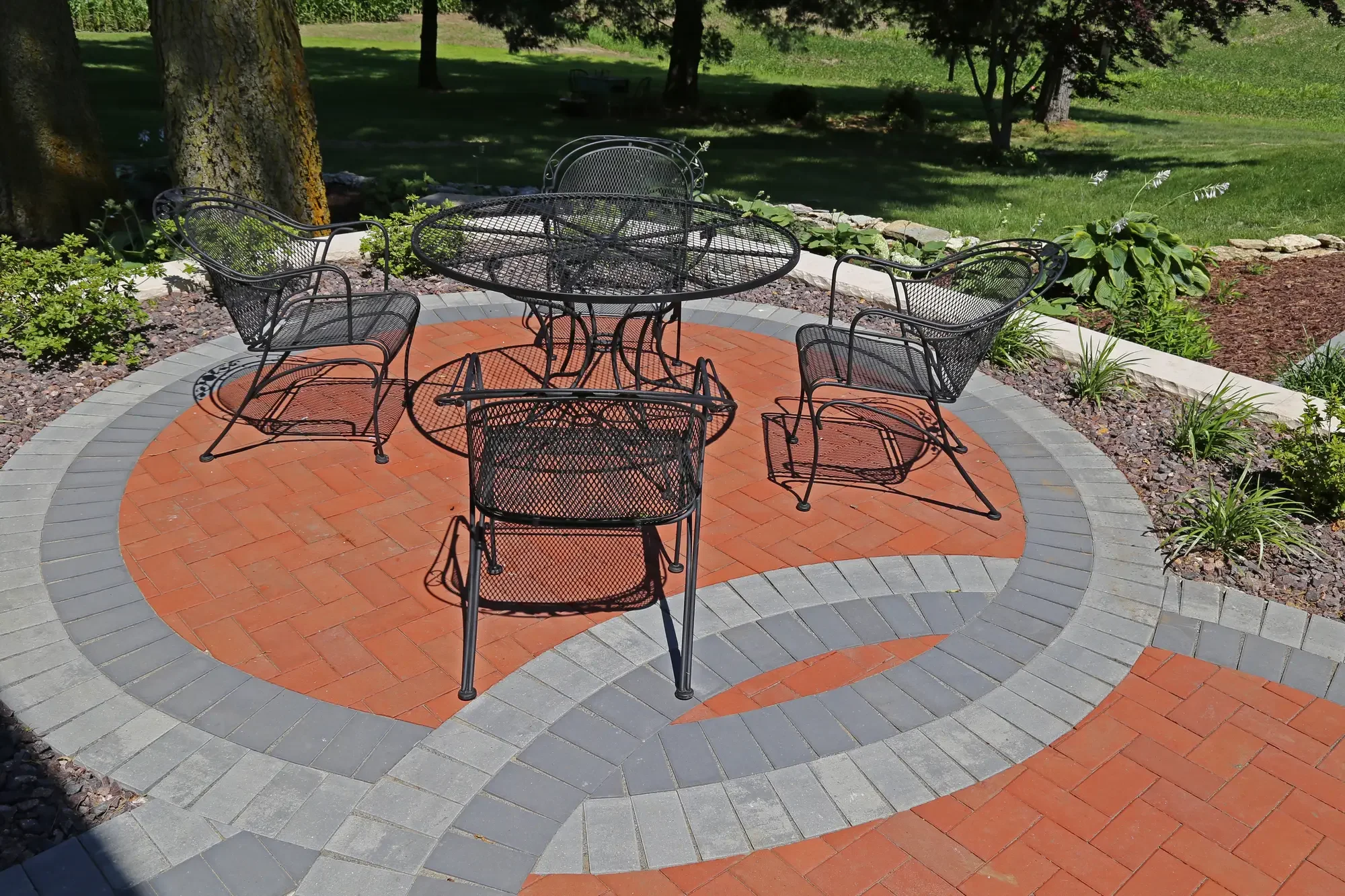 Circular two-tone paver patio with wrought iron dining set at The Prairie Pavilion by Green View in Illinois