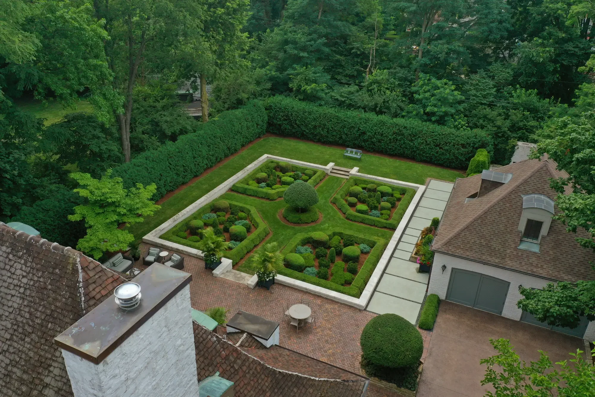 High aerial view of full estate property with formal knot garden, brick courtyard, and carriage house at The Tudor Knot Garden by Green View in Illinois