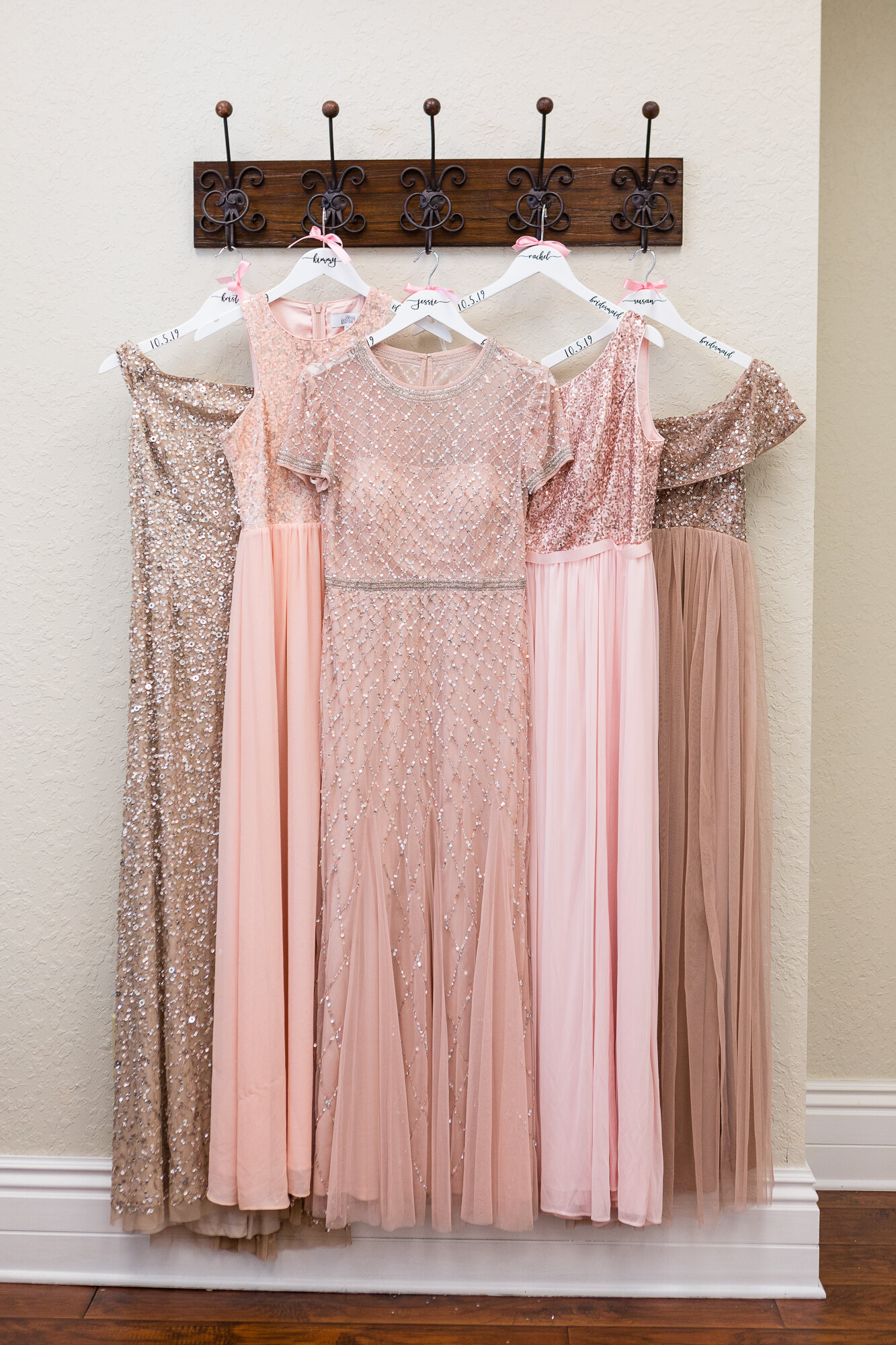 Shades of pale pink and rose gold bridesmaids dresses in a variety of figure-flattering styles.