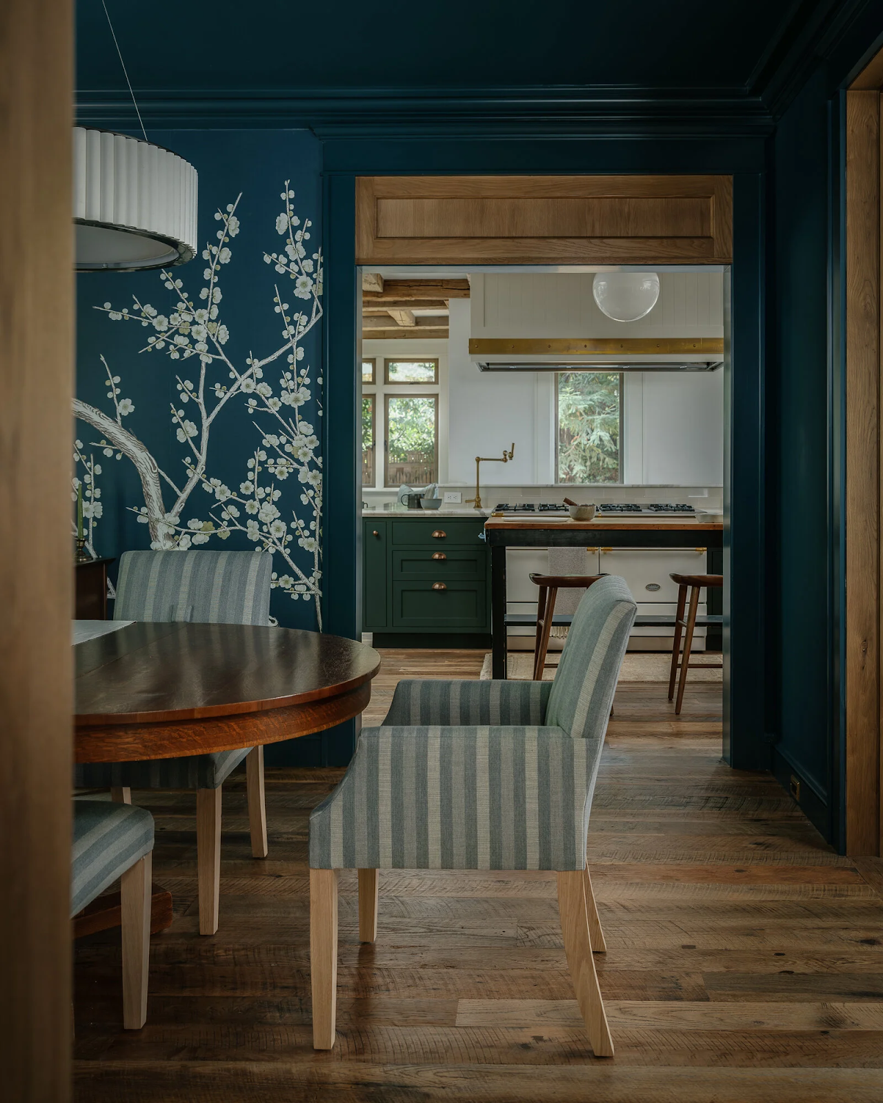 Layered sight lines from dining room through kitchen showing reclaimed original growth oak flooring in Palo Alto Craftsman restoration by Lane McNab Interiors and Holler Architects