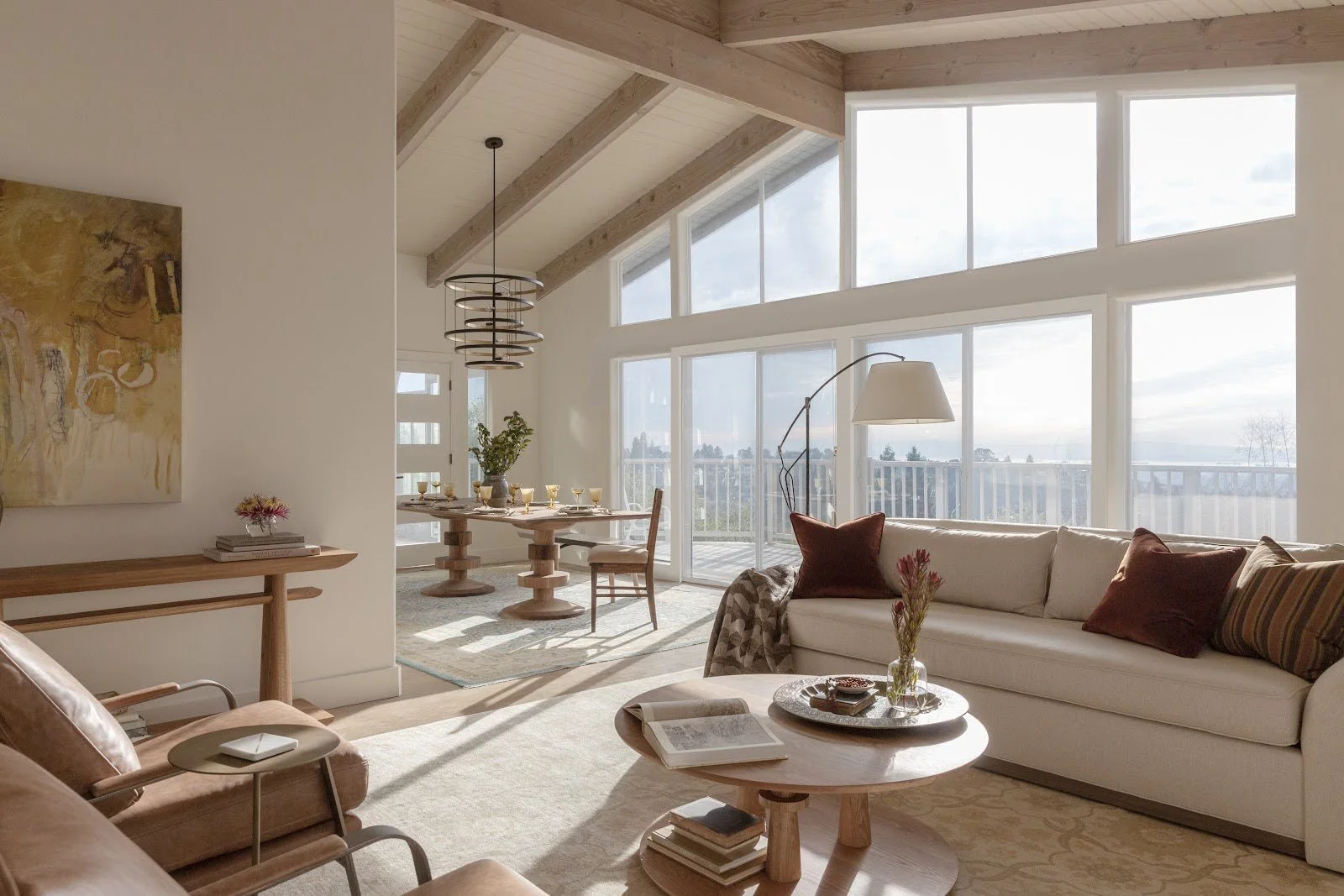 Modern living room featuring GUILD by LMI furniture including Monument side table and custom upholstery in bright space with floor-to-ceiling windows designed by Lane McNab Interiors
