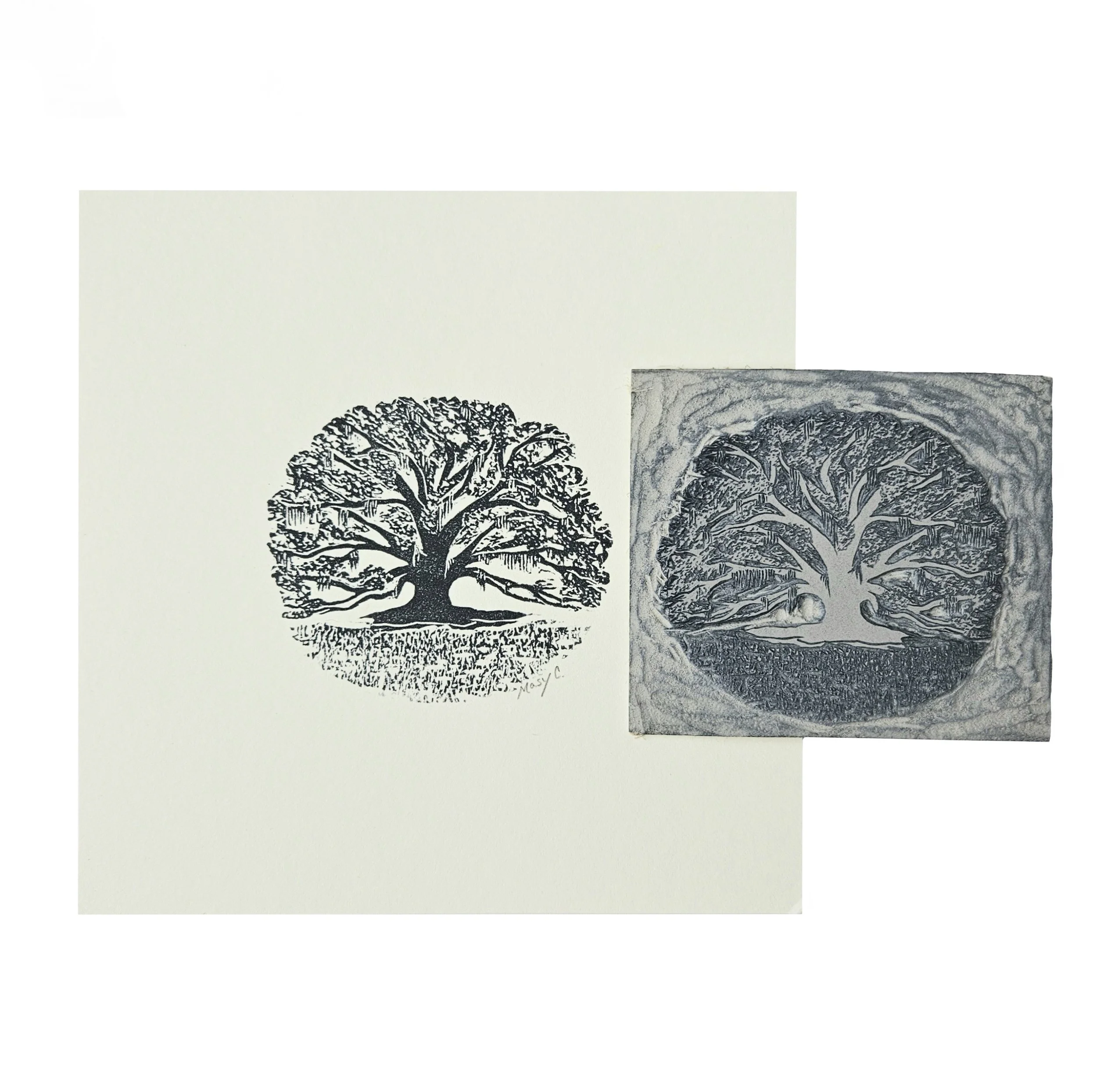 Original block print of an oak tree with moss printed in gray ink on off white paper. Hand carved linocut used for printing is laying next to it to show the process of relief printing.