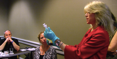 Dr. Roberts teaching a hands-on lecture course to other medical professionals about PRP. In this image, she demonstrates how to extract the PRP after the centrifuging process.