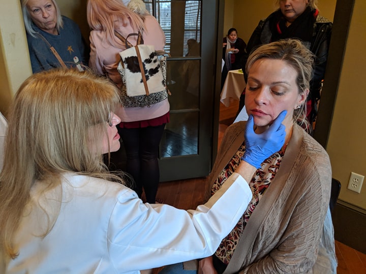 Dr. Roberts evaluating a model before a filler treatment at an aesthetic open house on December 8th, 2018.