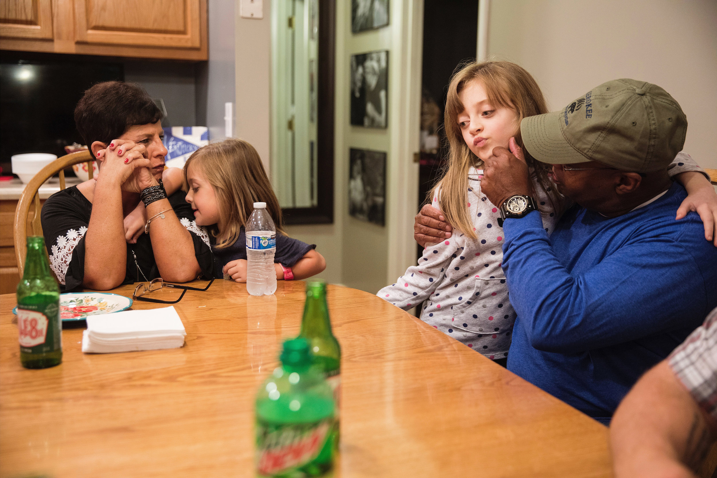  Wayne embraces his granddaughter, Makynleigh, 7, as Anniston, 5, clings to Christy at dinner. For Wayne, his four granddaughters are his world, and he and Christy care for them after school most days during the week. After a long day of work at the 