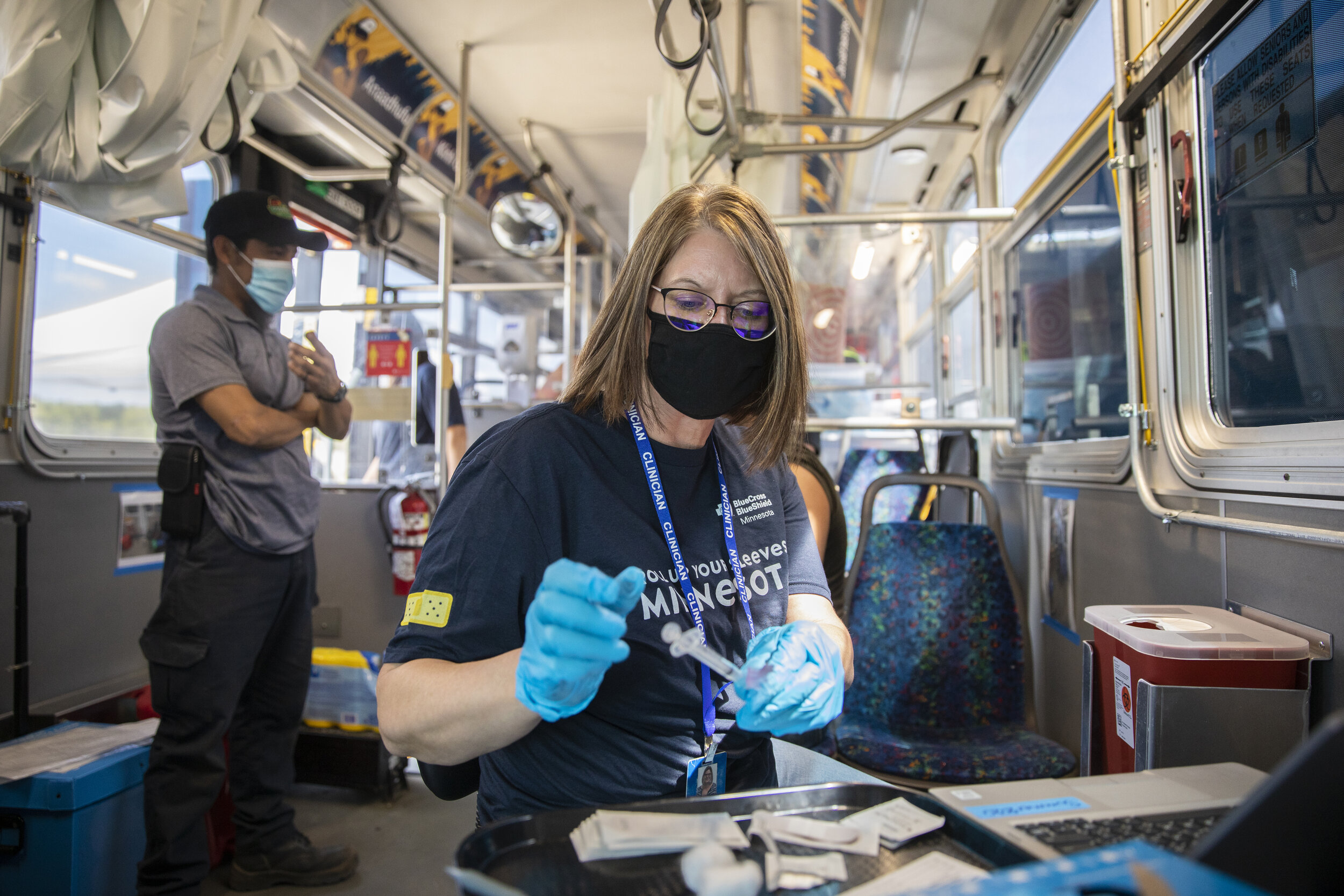  Amy Rewey prepares to administer the Covid-19 vaccine to an employee of Svihel Vegetable Farm aboard the mobile clinic. (Liam James Doyle for The New York Times) 