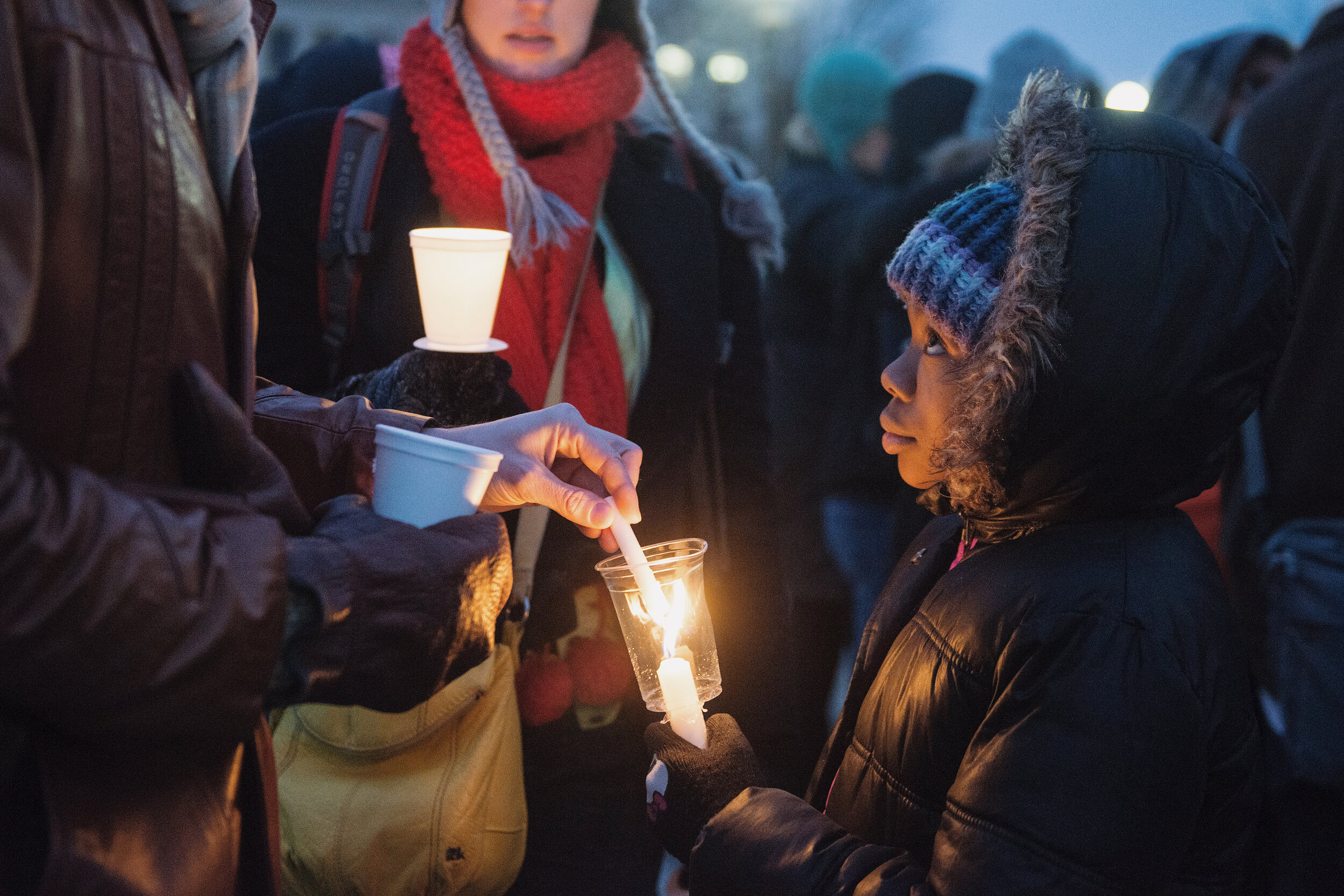  Khilanni Easterling helps ignite the candles of demonstrators in front of the Minnesota State Capitol on Martin Luther King Jr. Day, Jan. 19, 2015. For Minnesota Daily. 