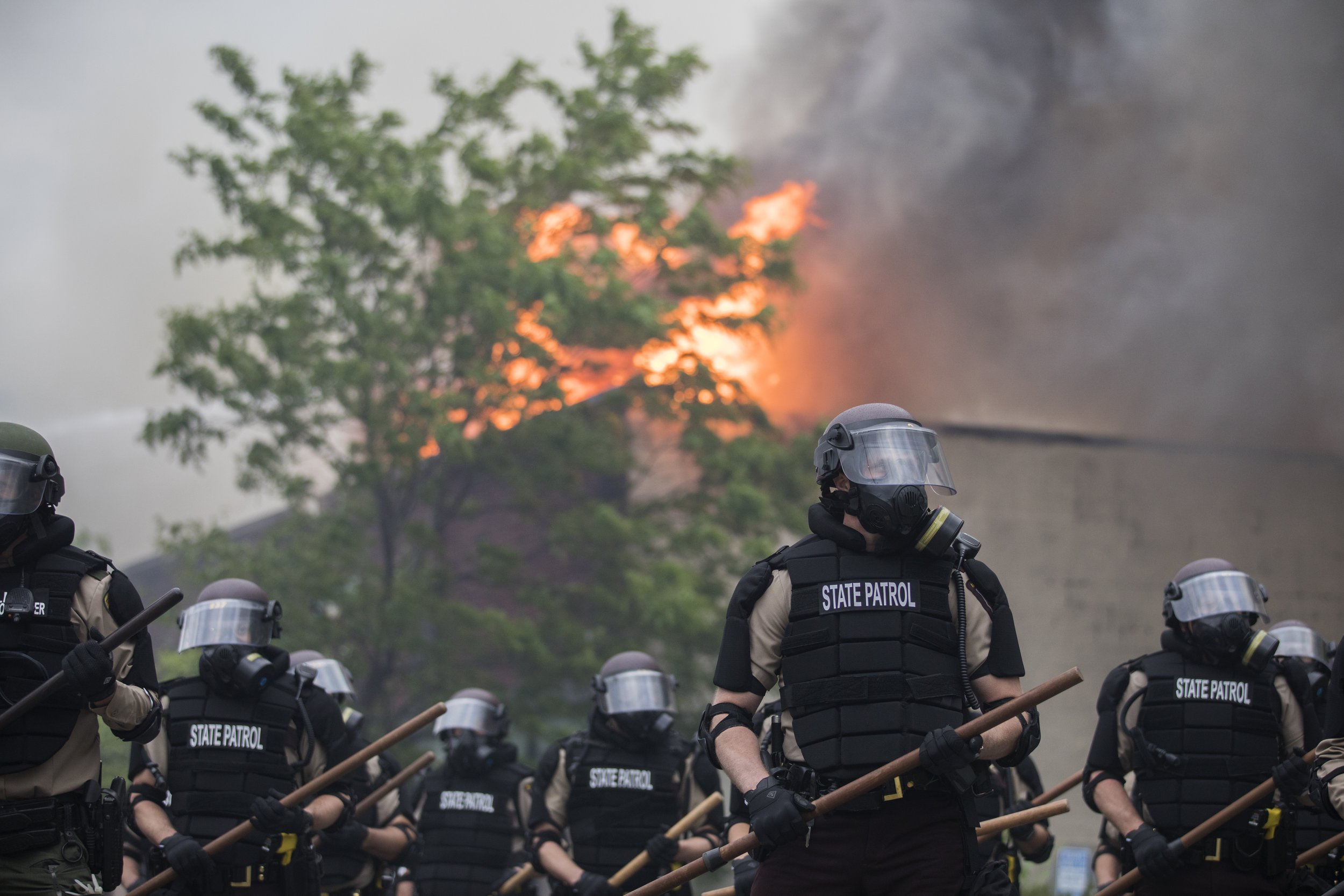  State Patrol officers guard burning buildings on South 27th Avenue, south of East Lake Street in Minneapolis on Friday morning, May 29, 2020. Fires continued to burn after protests over the death of George Floyd broke out for a third straight night.