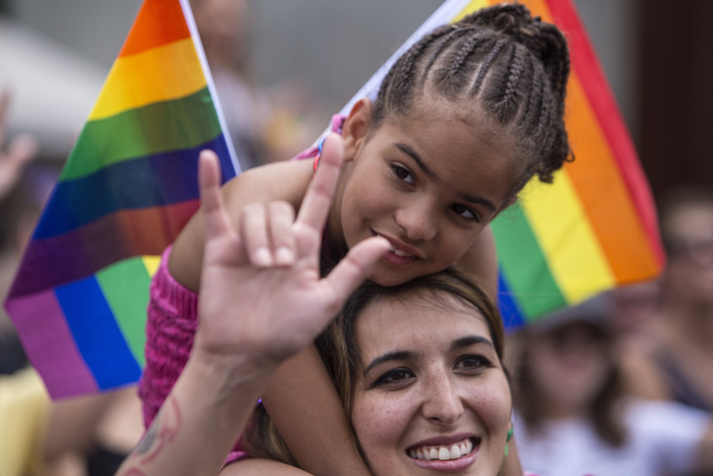  Natalie Deeble shows a sign of love with her daughter Saniya, age 8, on her shoulders during the 2018 Twin Cities Pride parade in Minneapolis. (Liam James Doyle for MPR News) 