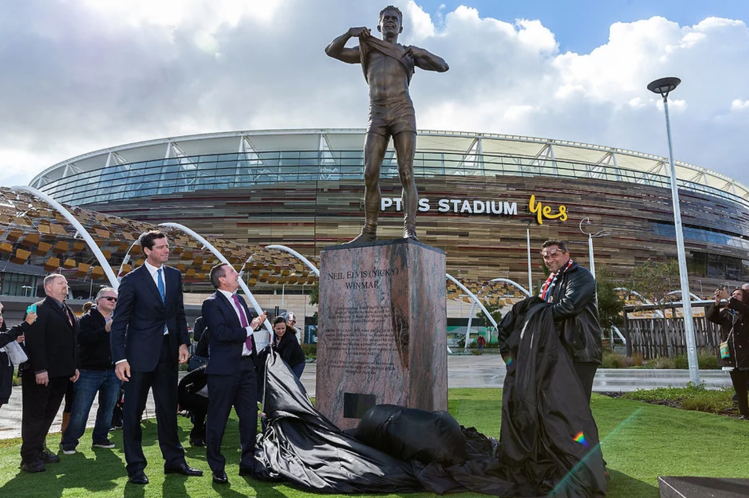 The statue is unveiled by CEO of the AFL Gillon McLachlan, the Premier of Western Australia Mark McGowan, and the great man himself.