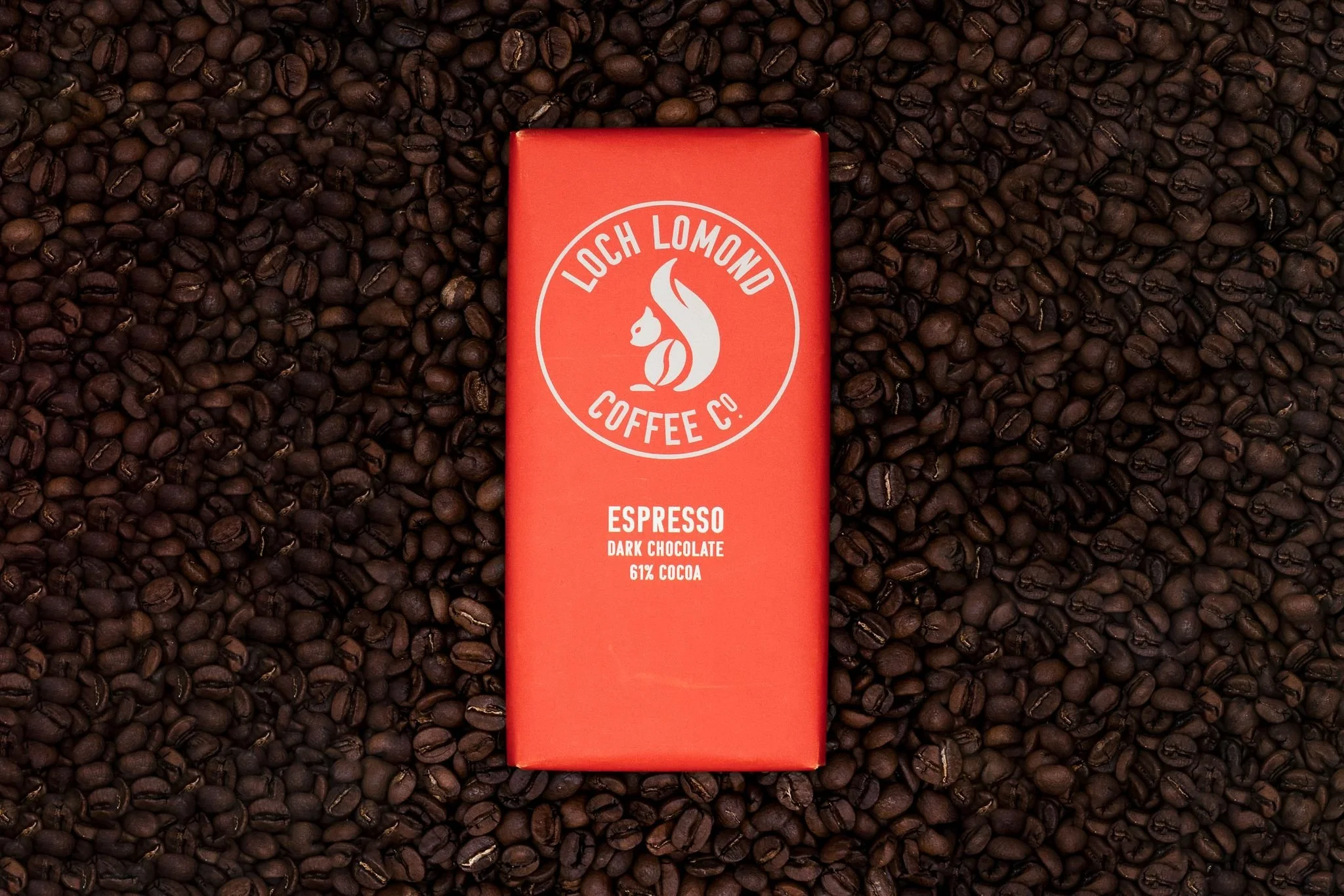 Six disposable coffee cups with colorful lids, featuring the Loch Lomond Coffee Co. logo, arranged in a pyramid shape on a white surface.