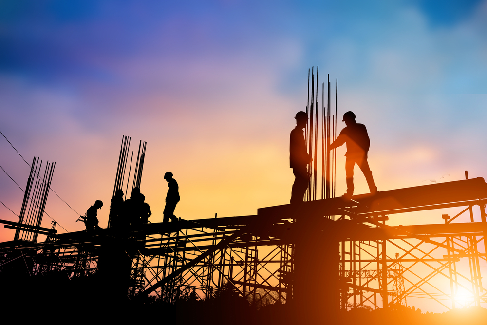 Workers working on a building during sunset