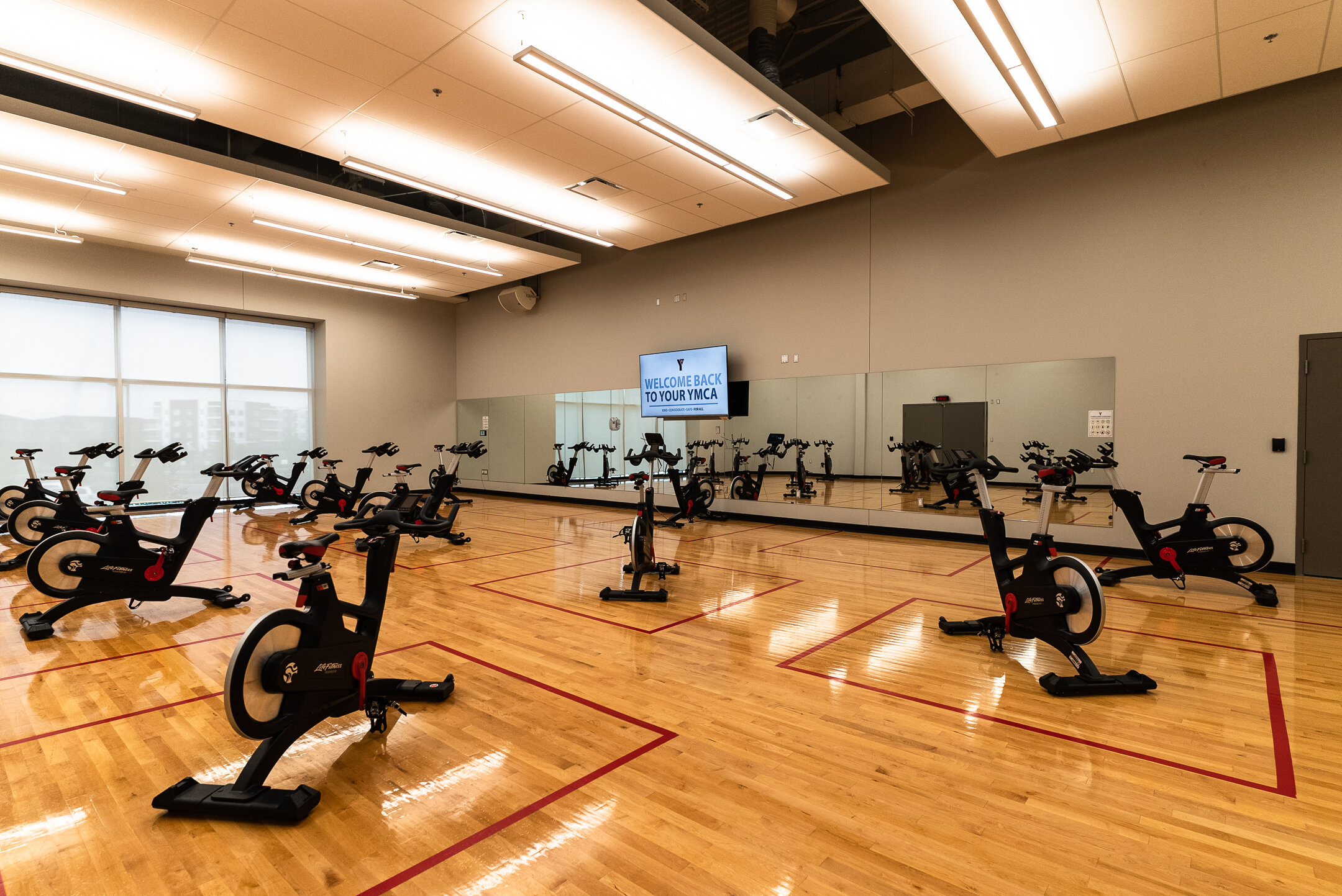  YMCA at Seton fitness studio with spin bikes, with audio and video system designed and installed for remote fitness options.  