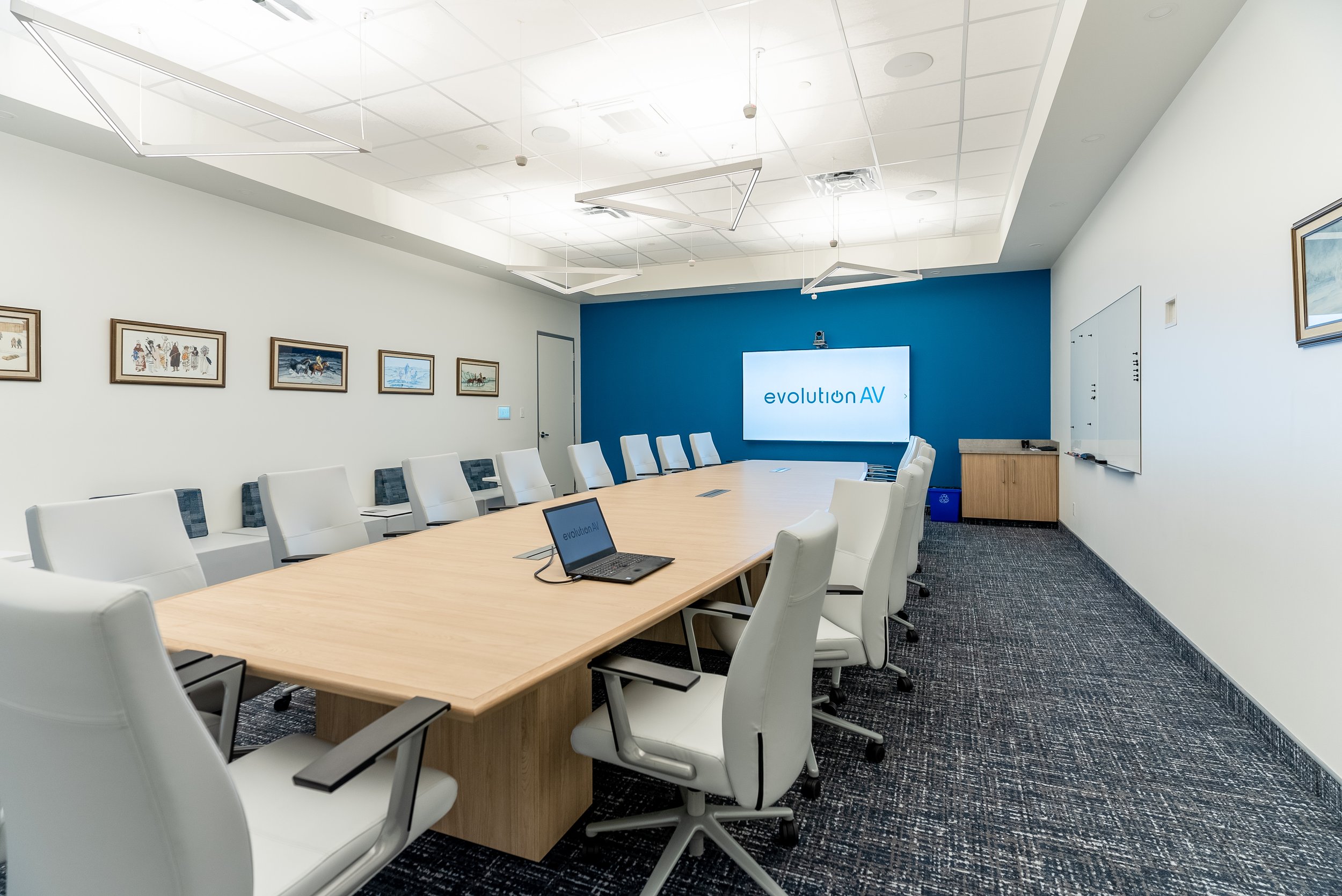  A large boardroom with an interactive display and a table mounted HDMI cable. 