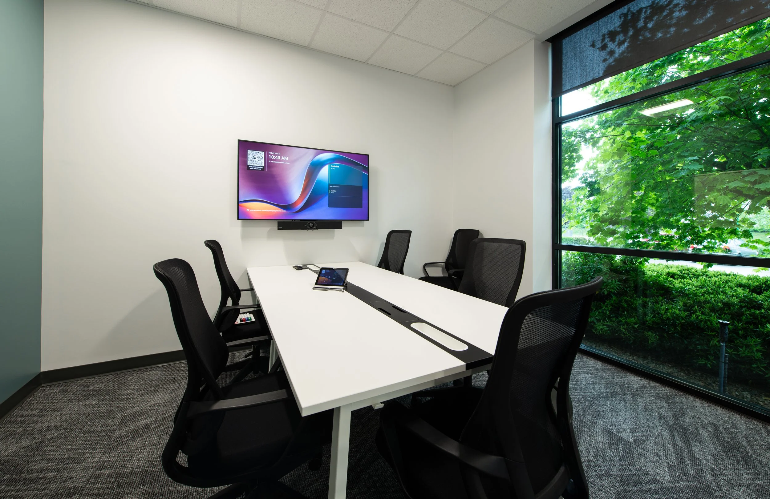 Meeting room with display and conferencing bar