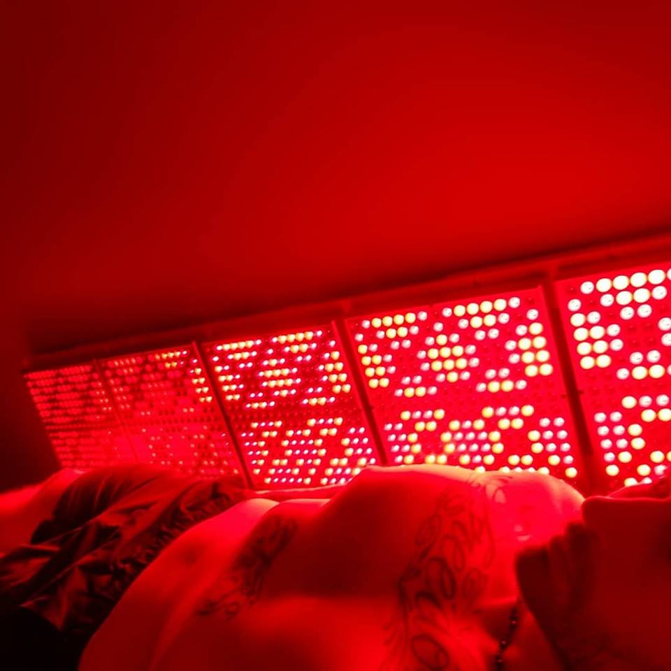 Person inside Innovative Health and Performance REDjuvenator red light therapy box