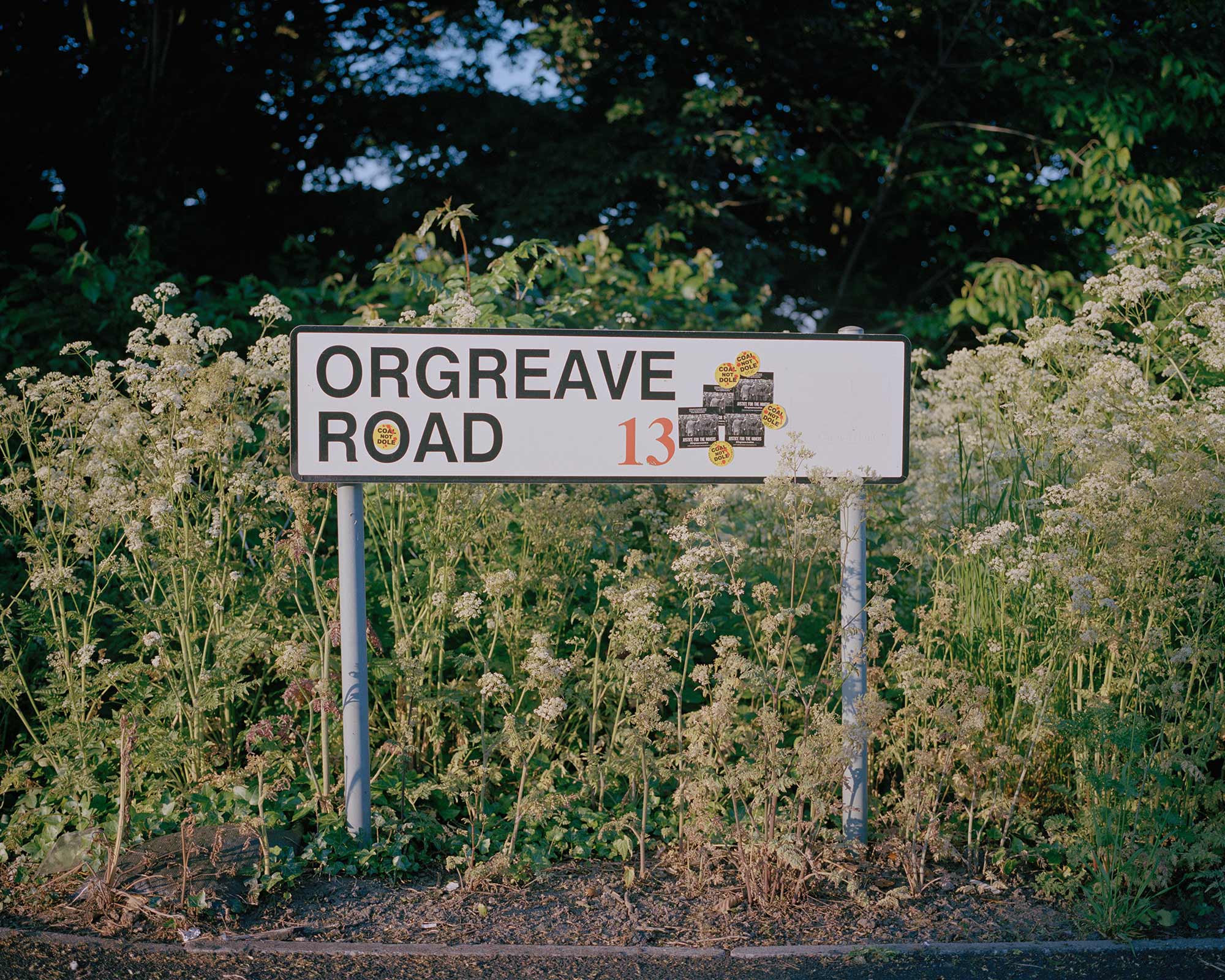 Road sign adorned with Orgreave Truth and Justice Campaign stickers, Orgreave, South Yorkshire.