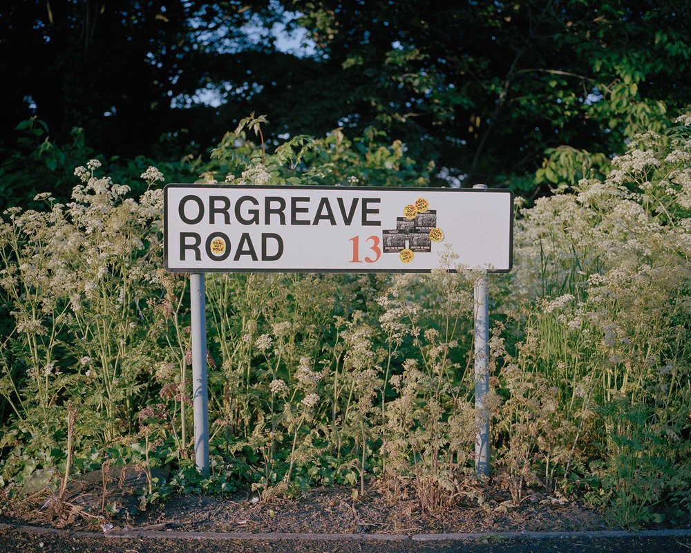 Road sign adorned with Orgreave Truth and Justice Campaign stickers, Orgreave, South Yorkshire.