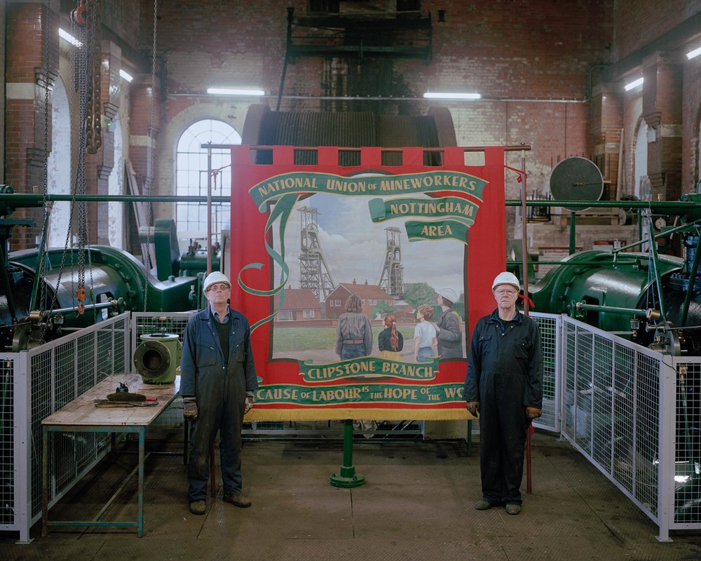 Volunteers at the restored Pleasley Colliery, posing with the National Union of Mineworkers Clipstone Branch banner.