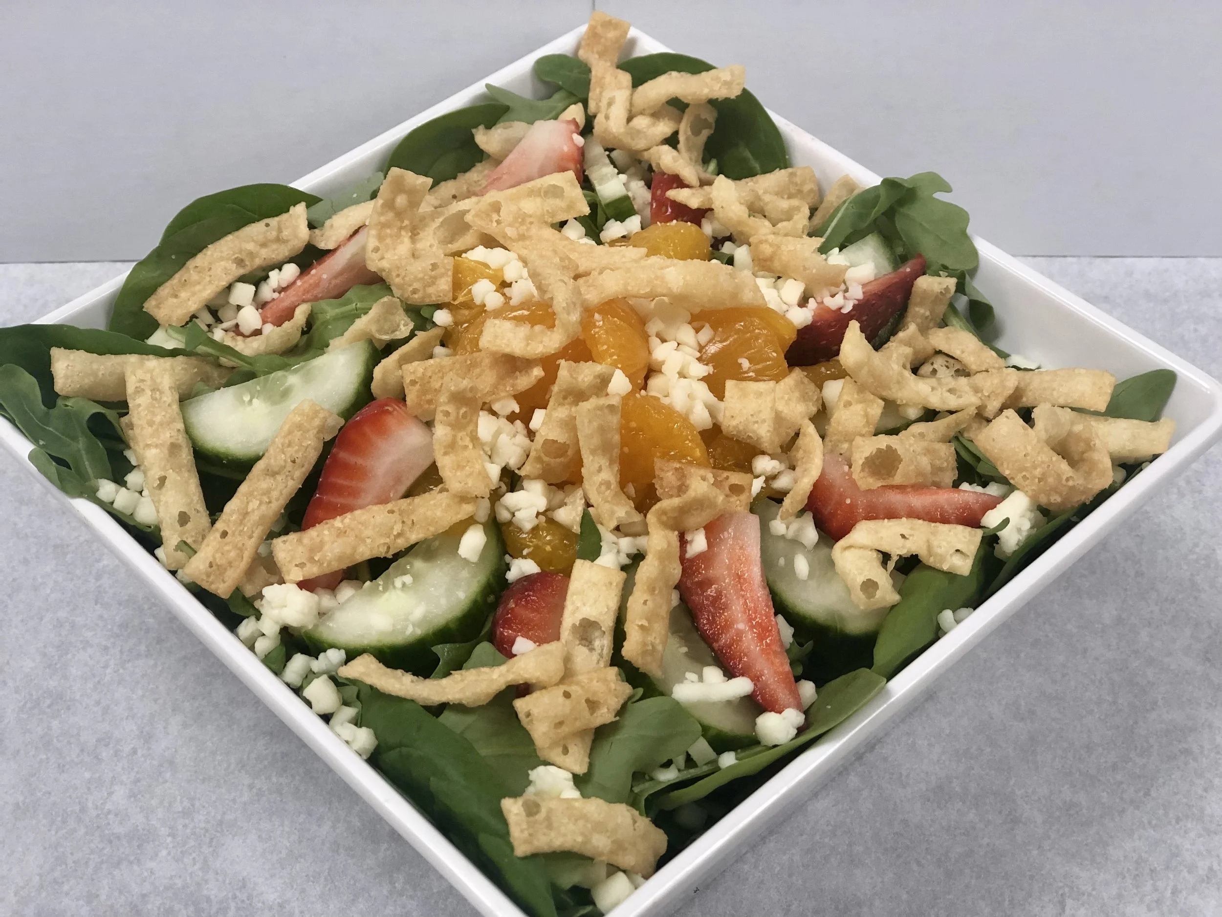 Summer Salad Strawberries, mandarin oranges, mozzarella cheese, cucumbers, and won-ton strips over a bed of spinach and arugula. Small: 8.99 Large: 10.99