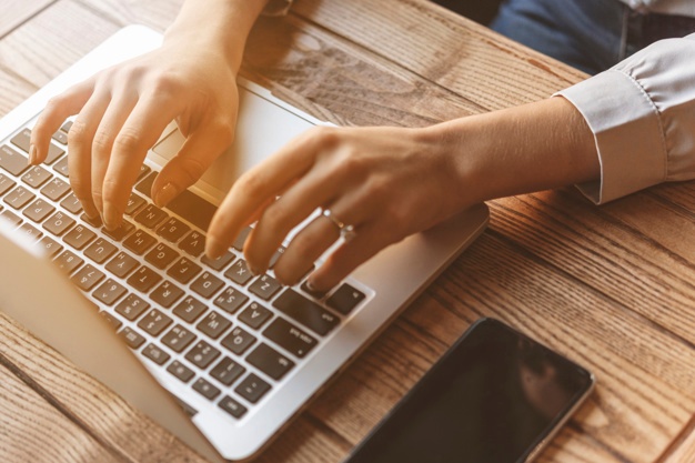 close-up-woman-typing-laptop-coffee-shop_23-2148022505.jpg