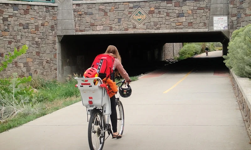 A mama cycling with her toddler on a bike path in Boulder, Colorado. 