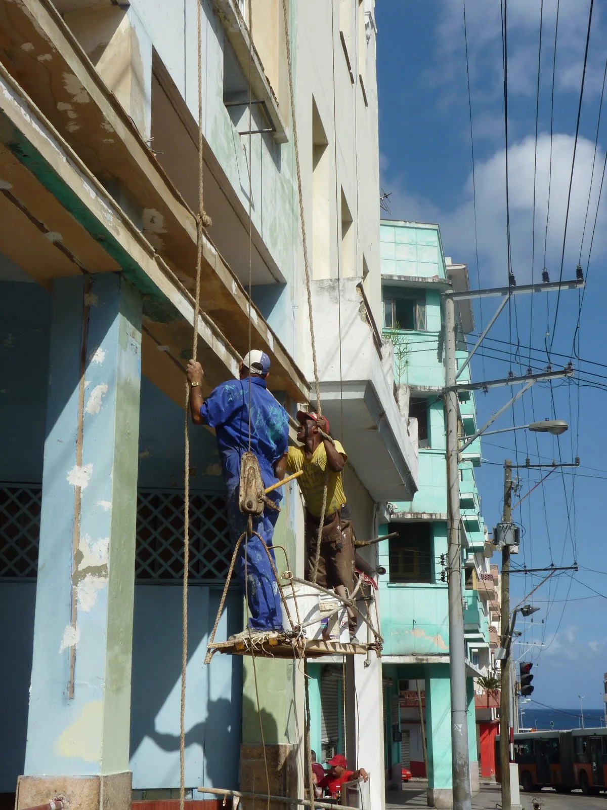 Two men working on a building.