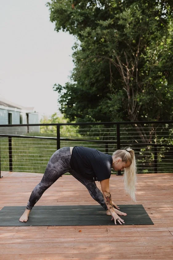 Pyramid (Parsvottanasana) Inhale into Pyramid to prepare to move into triangle. (In this photo, Joella’s back toe should be pointing toward the top of her mat. (-: )