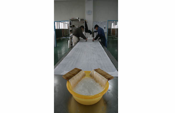 The silk is glued onto a paper backing