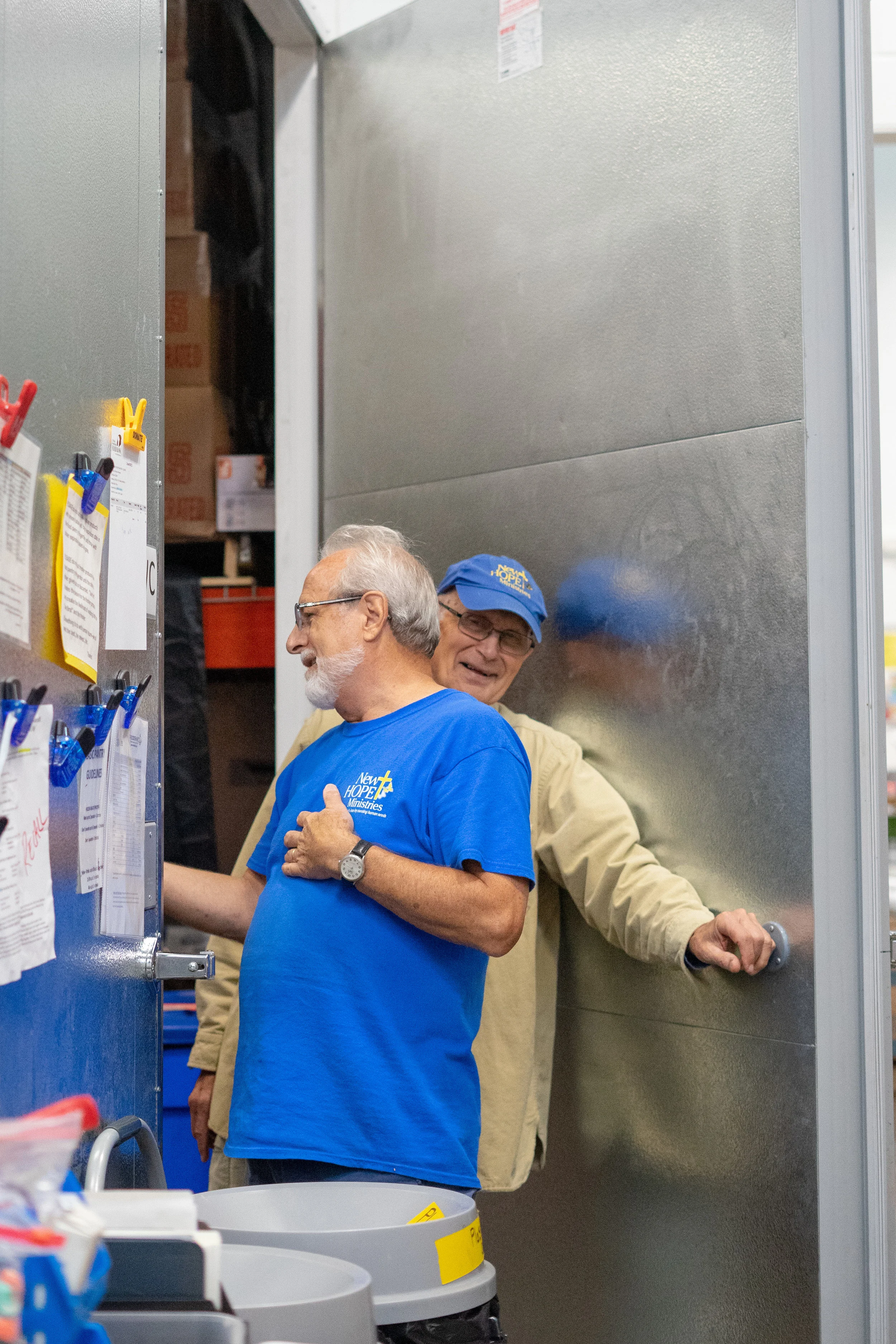 Volunteers Dave (closest to camera) and Dick share a joke while volunteering at the food pantry. The pair has been working at the pantry for many years and have become friends with many of the volunteers and guests that come in to use the organization's services.