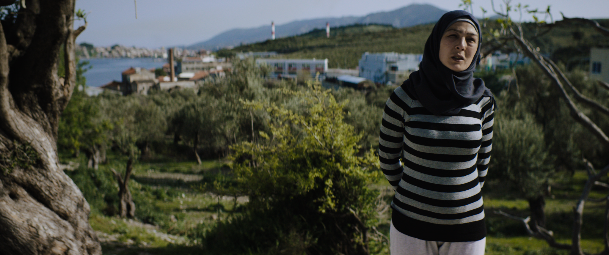 Syrian Refugee Woman Standing on Green Hillside in Camp Kara Tepe Lesvos Greece