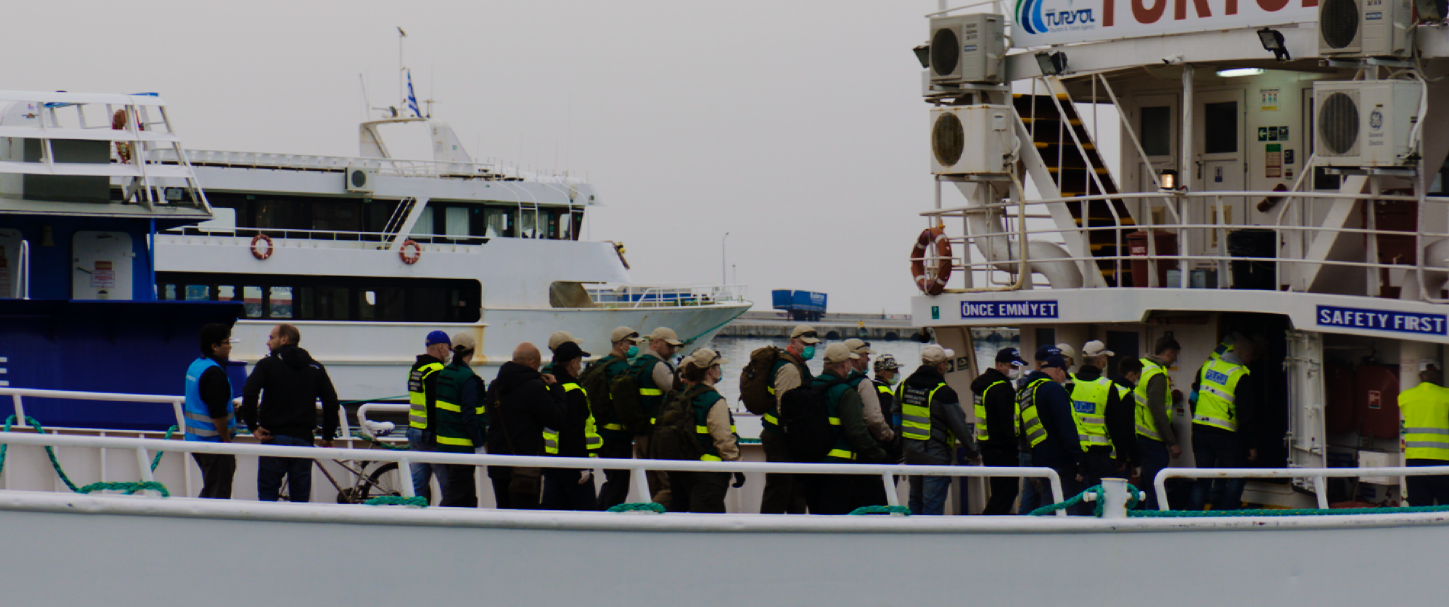 Officials Escort Refugees onto Boat for Deportation to Turkey
