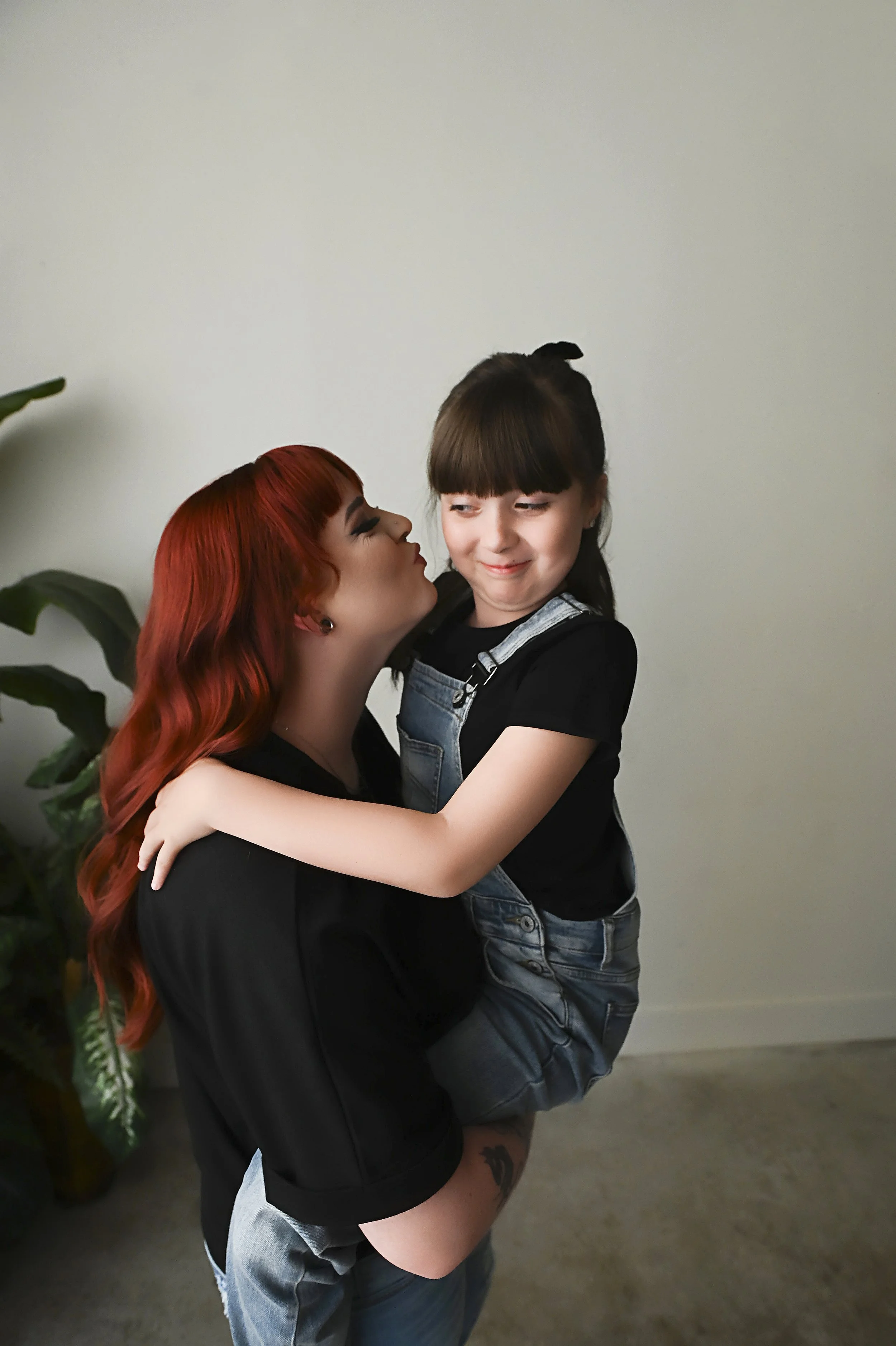 mother holding daughter during playful lifestyle motherhood photography session
