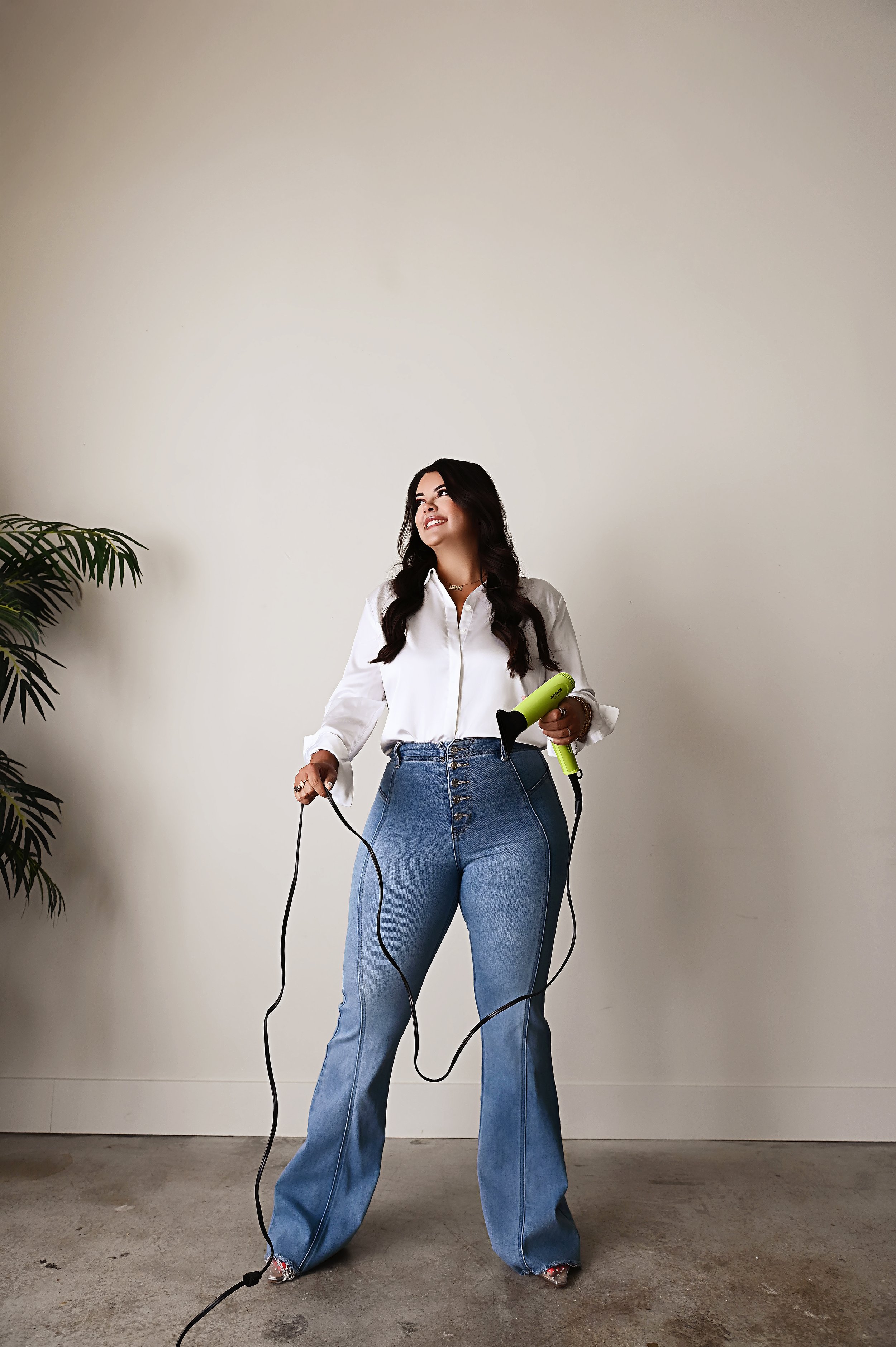 Lifestyle branding photo of Shreveport hair stylist Britney holding professional hair tools in studio
