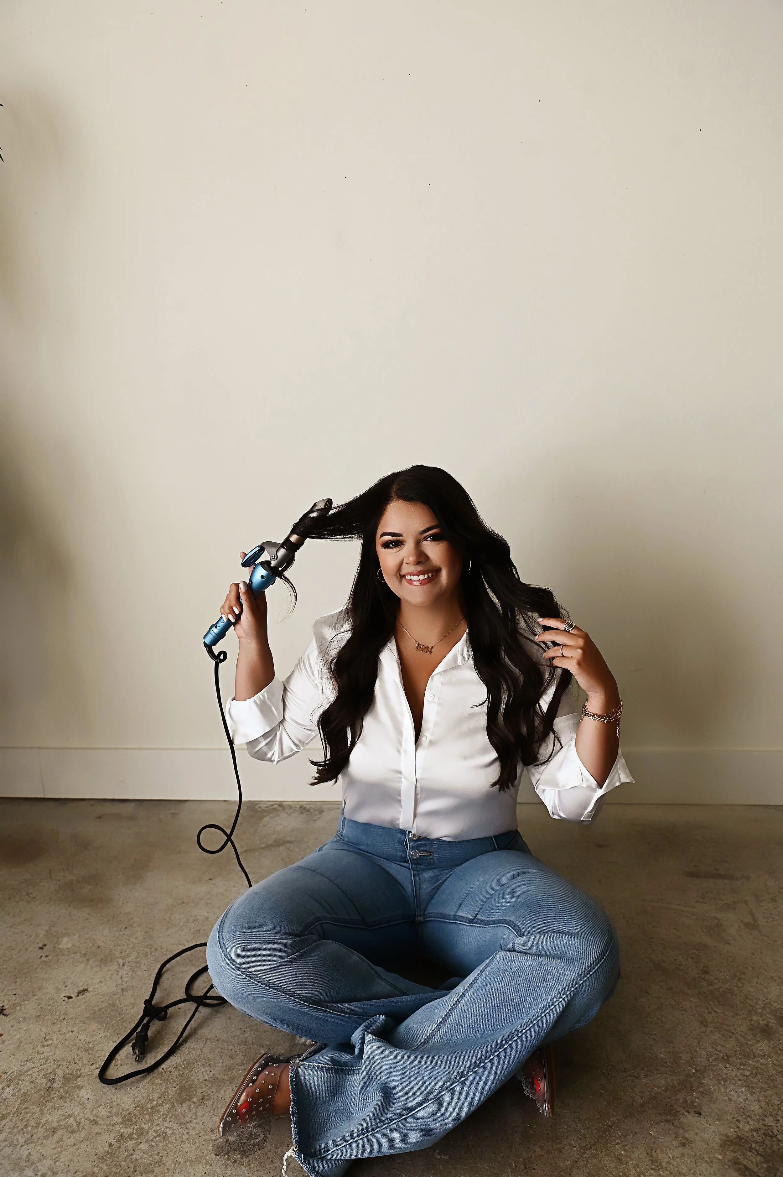 Seated branding portrait of Shreveport hair stylist Britney in a neutral studio environment