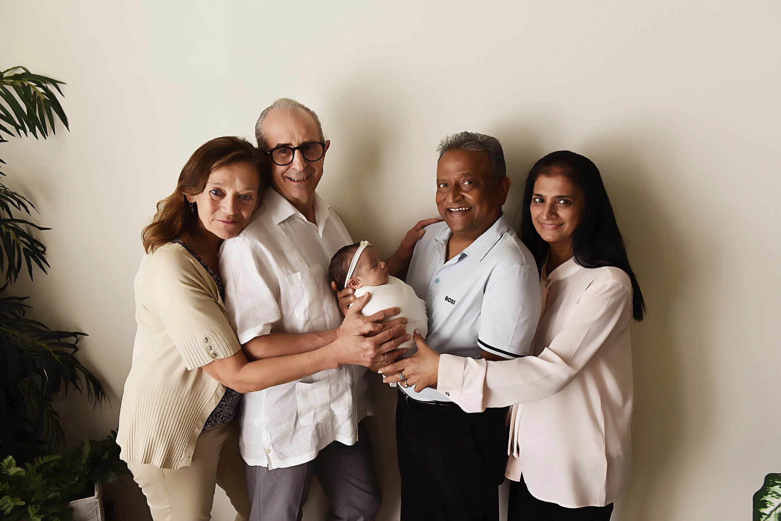 Newborn with both sets of grandparents in a studio family portrait