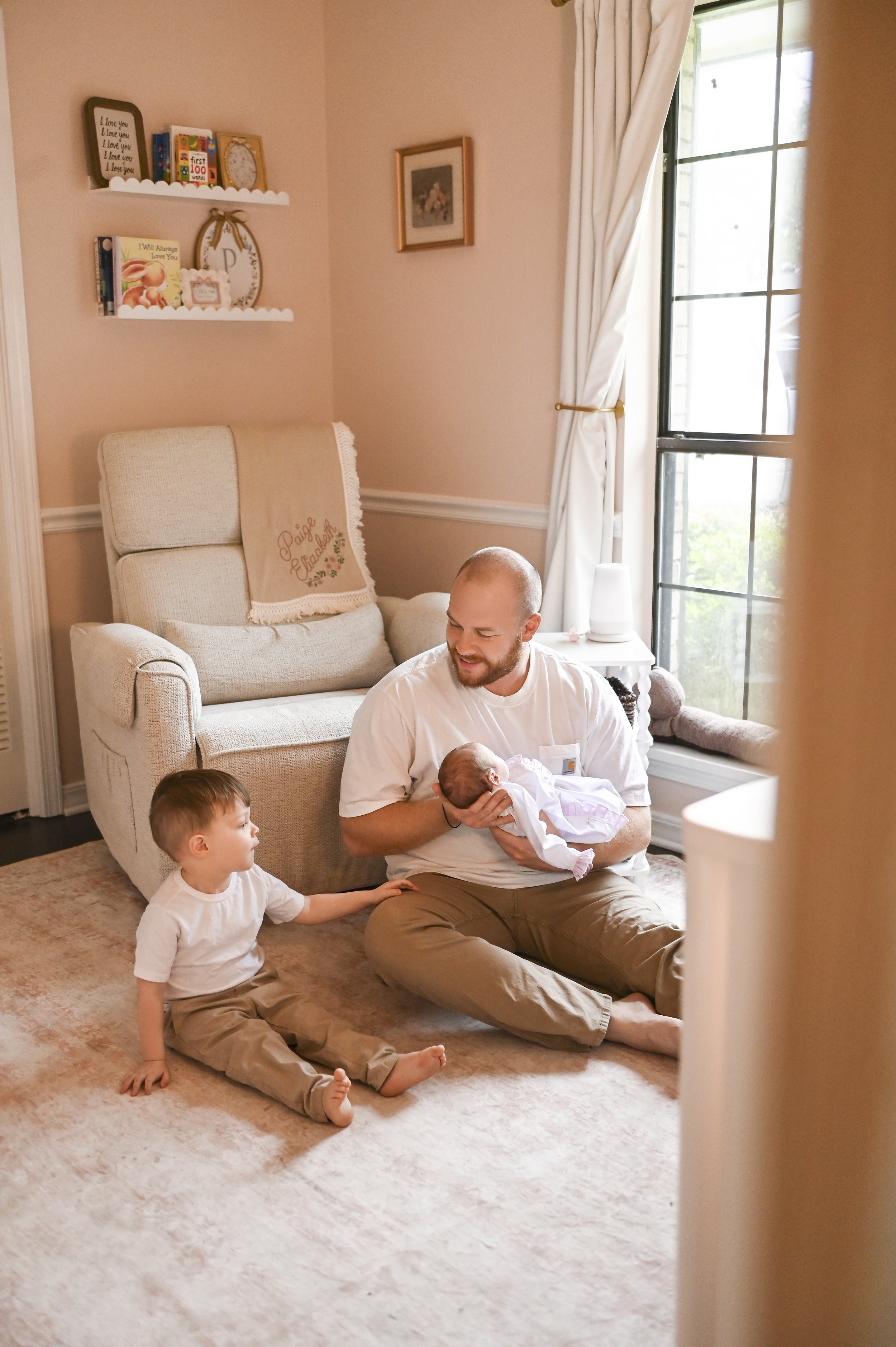 father holding newborn while toddler sits beside him during lifestyle session