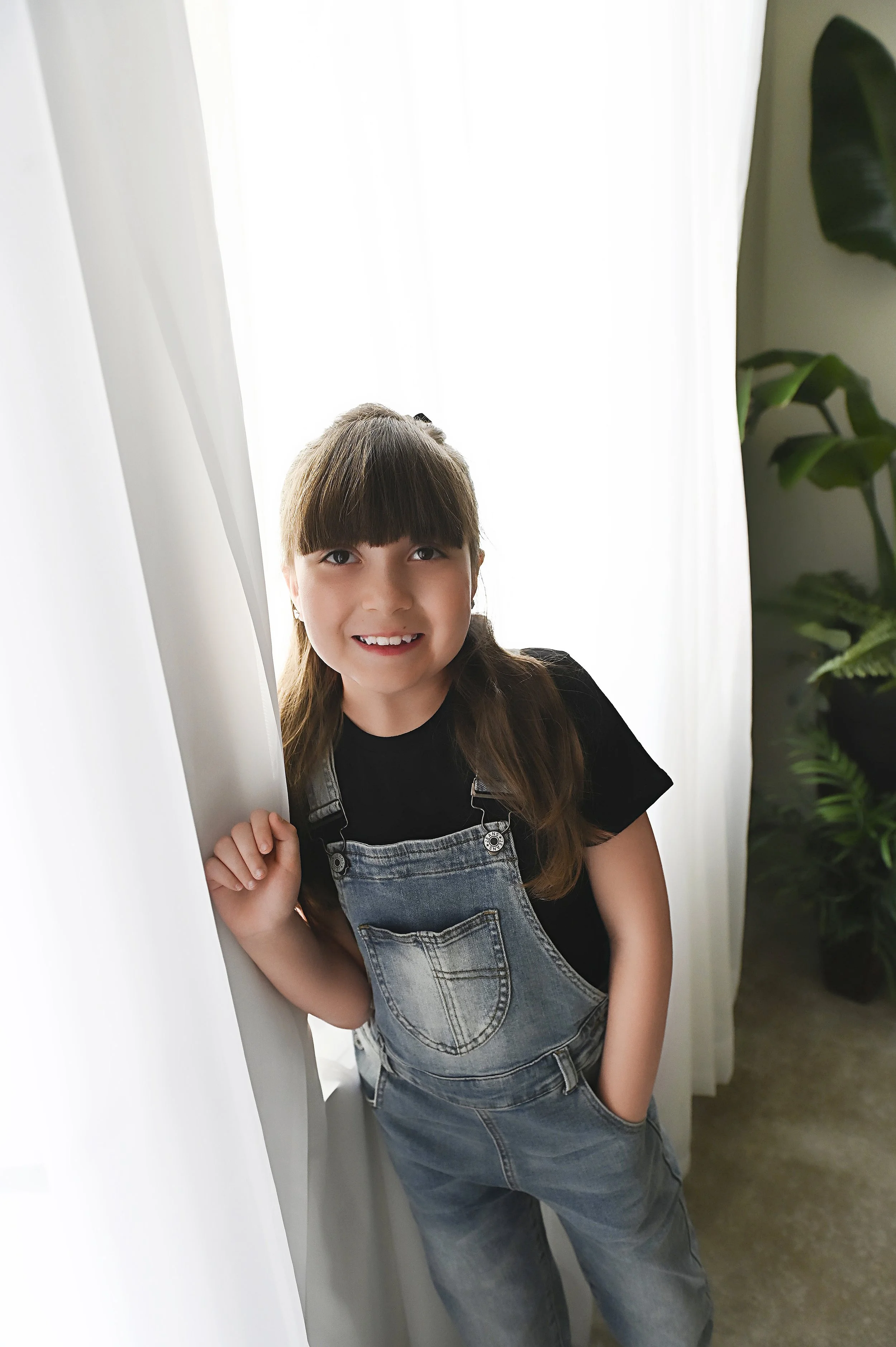 smiling child portrait near white curtains during natural light photography session