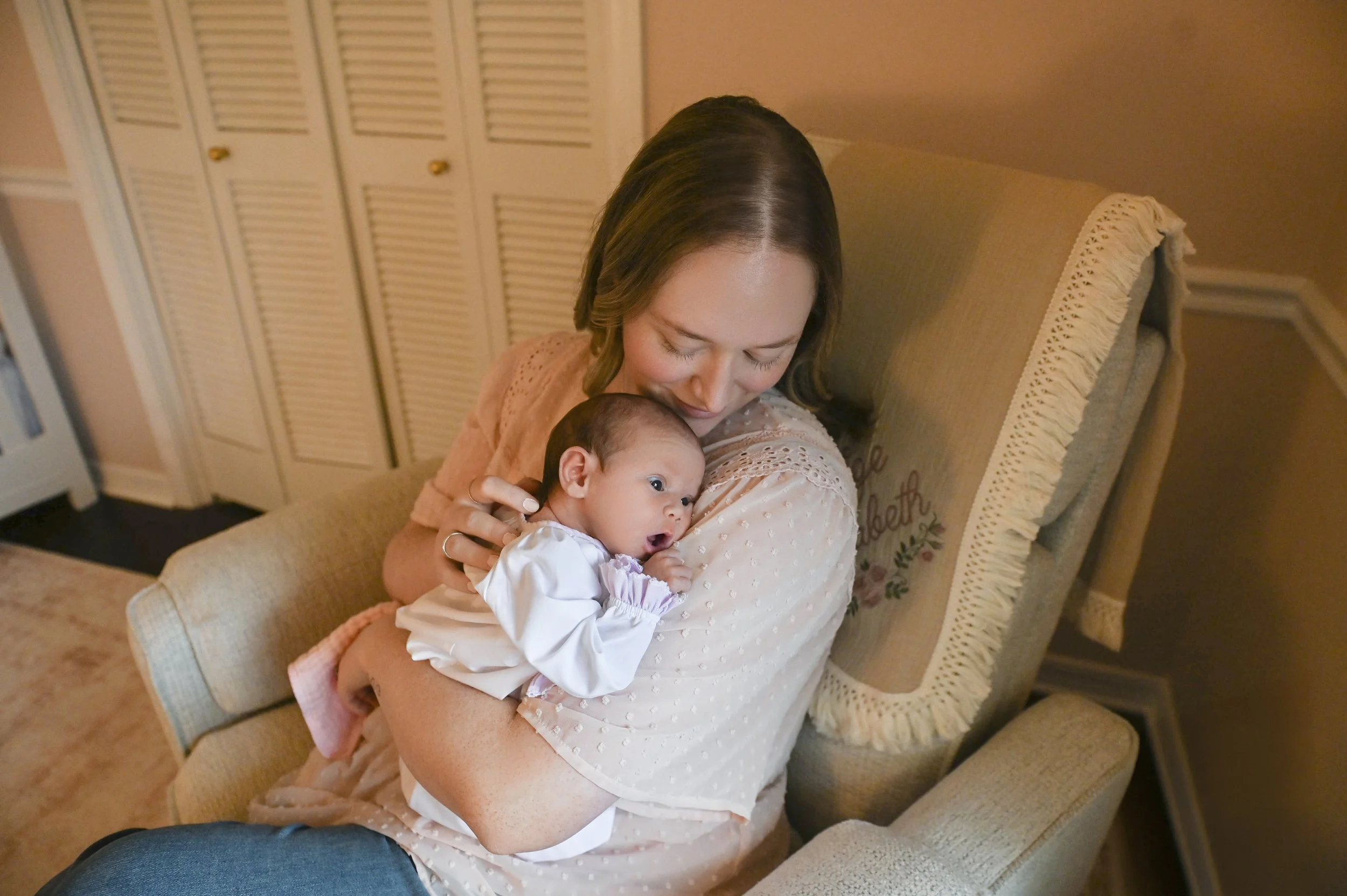mother holding newborn baby in soft nursery light in Shreveport Louisiana home