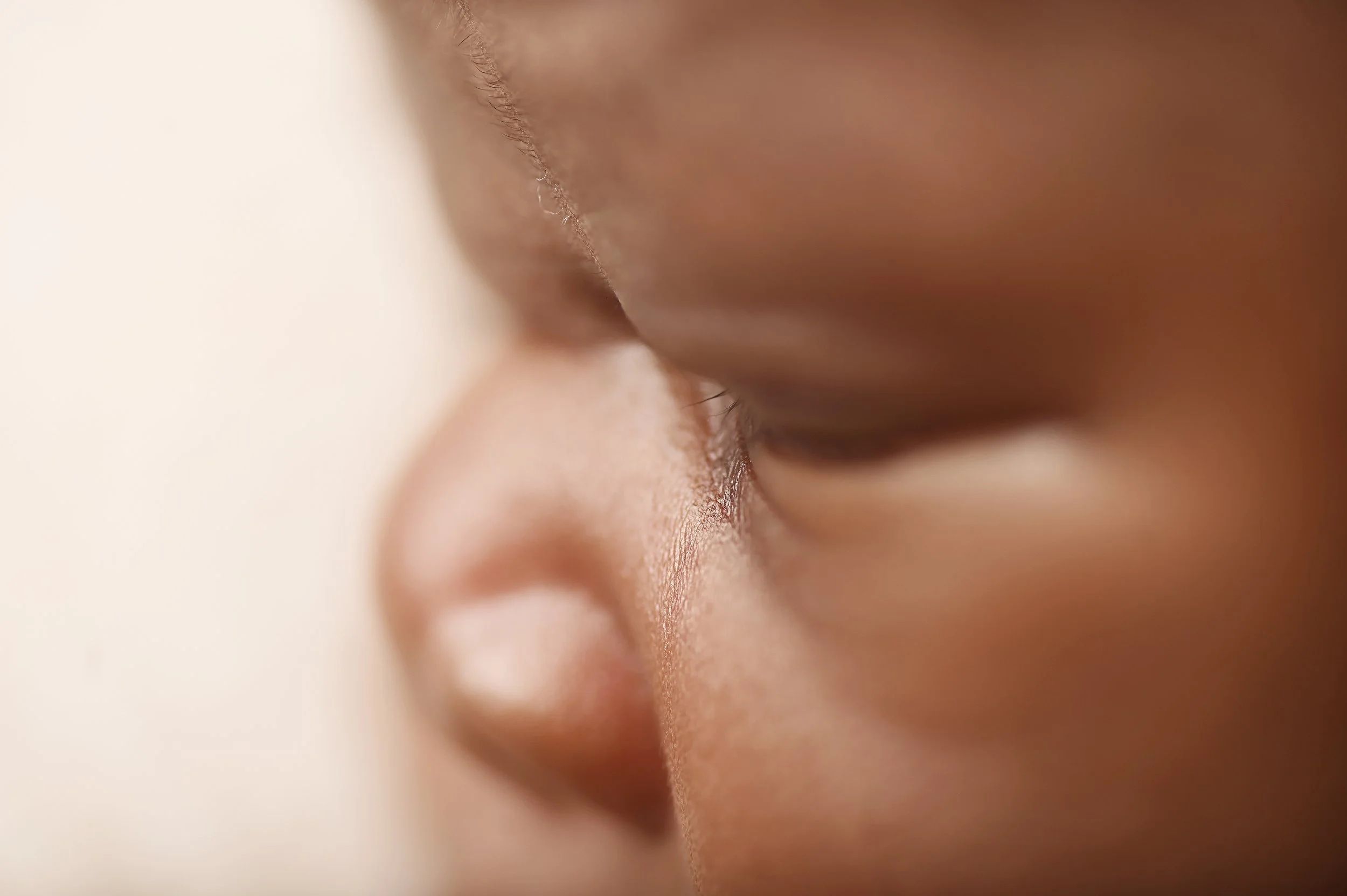 Close-up portrait of a newborn baby’s face and lips captured in a neutral studio newborn session in Shreveport.